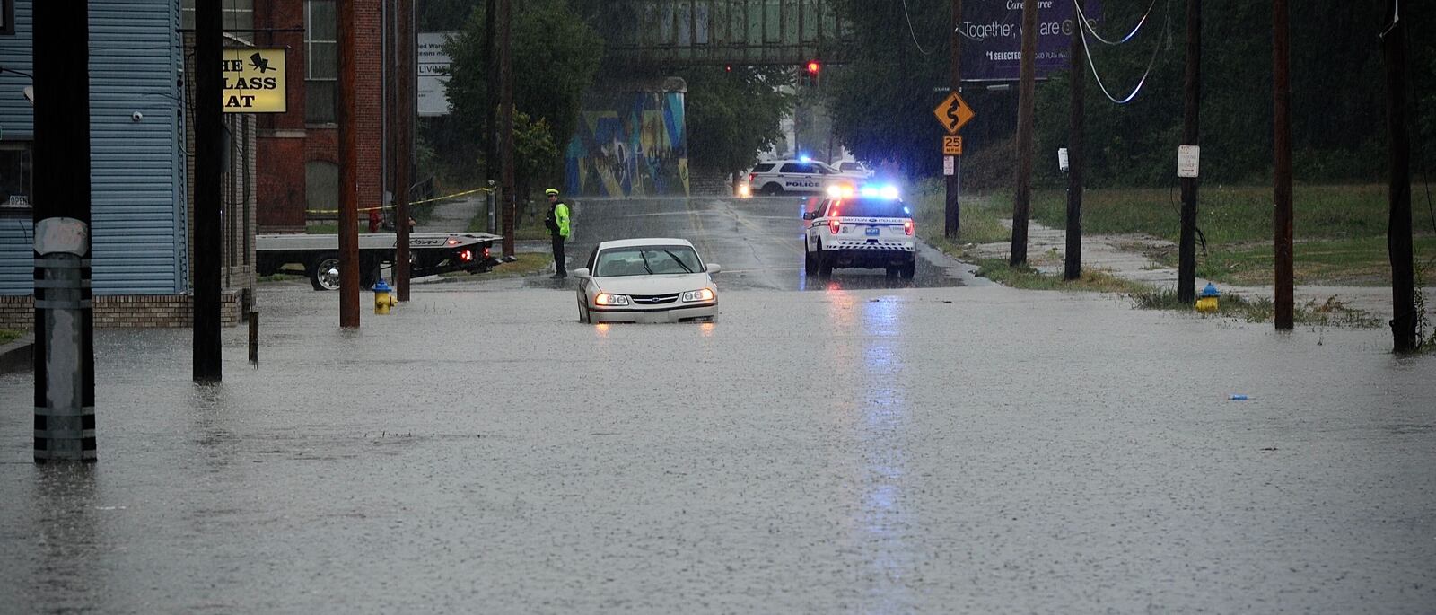 A car is stuck in high water on Linden Avenue in Dayton after thunderstorms on Thursday afternoon, Aug. 26, 2021, brought heavy rainfall. MARSHALL GORBY\STAFF