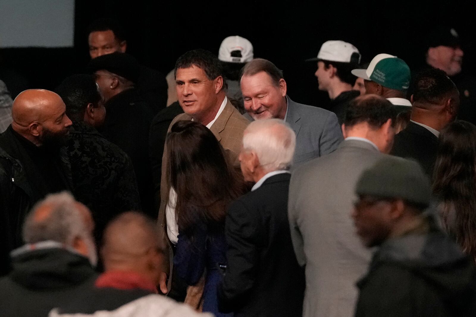 Former baseball players Jose Canseco, center left, and Carney Lansford, center right, greet others in attendance during a celebration of life for former Oakland Athletics baseball player Rickey Henderson in Oakland, Calif., Saturday, Feb. 1, 2025. (AP Photo/Jeff Chiu)