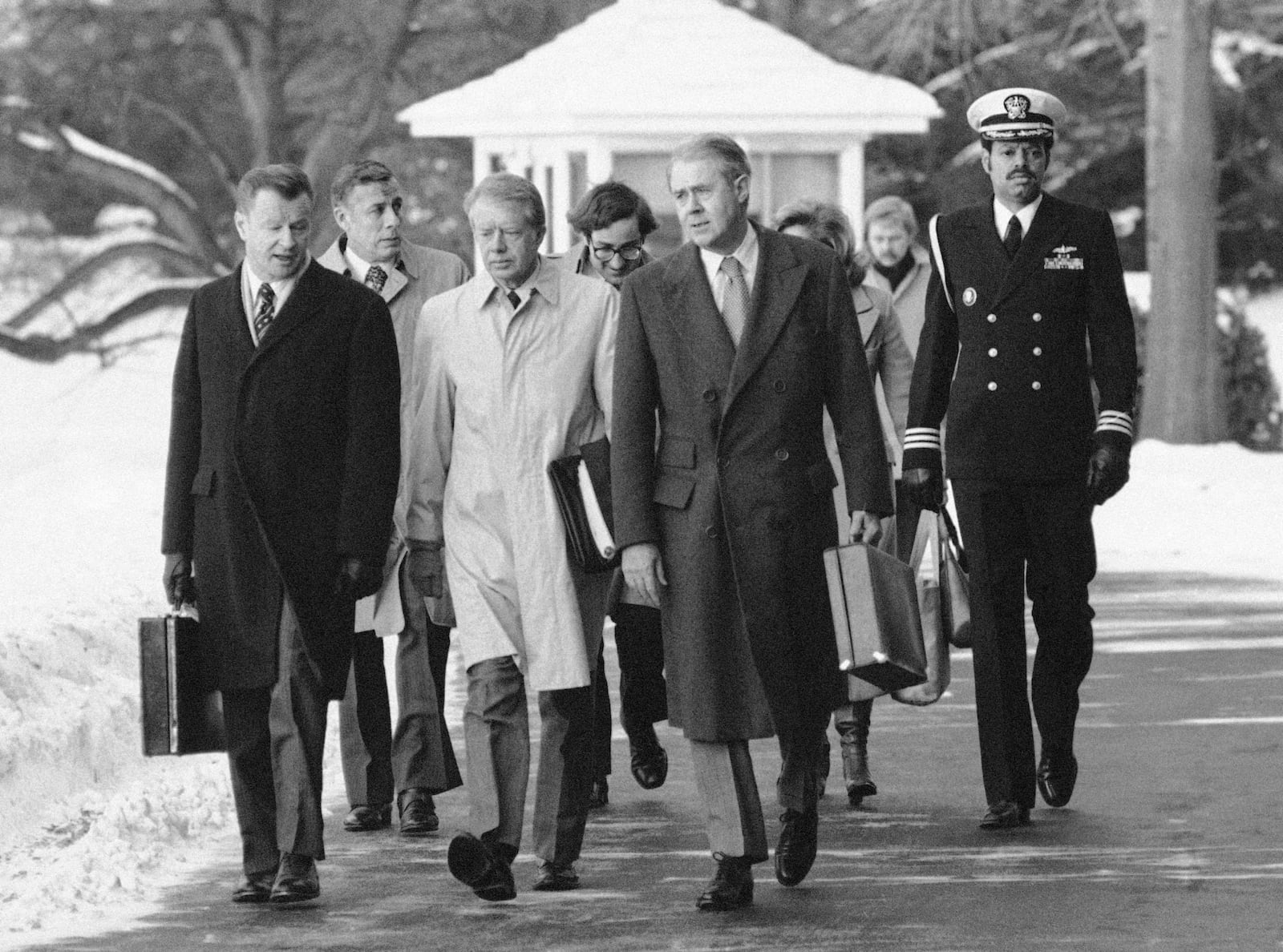 FILE - President Jimmy Carter, flanked by Secretary of State Cyrus Vance, right, and foreign policy adviser Zbigniew Brzezinski, left, walks toward a waiting helicopter to fly to nearby Andrews Air Force Base, Md., on the South Lawn of the White House in Washington, Feb. 14, 1979. (AP Photo/Bob Daugherty, File)