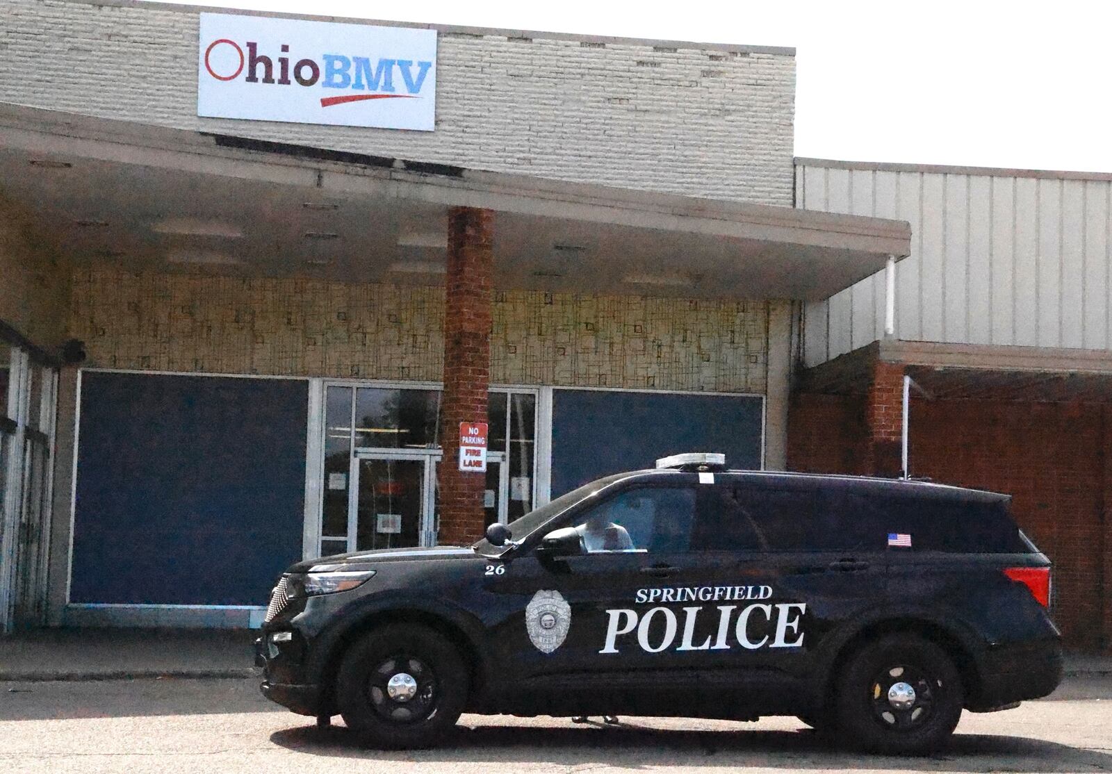 A Springfield police officer sits outside the closed Ohio BMV in the Southern Village Shopping Center Friday, Sept. 13, 2024. BILL LACKEY/STAFF