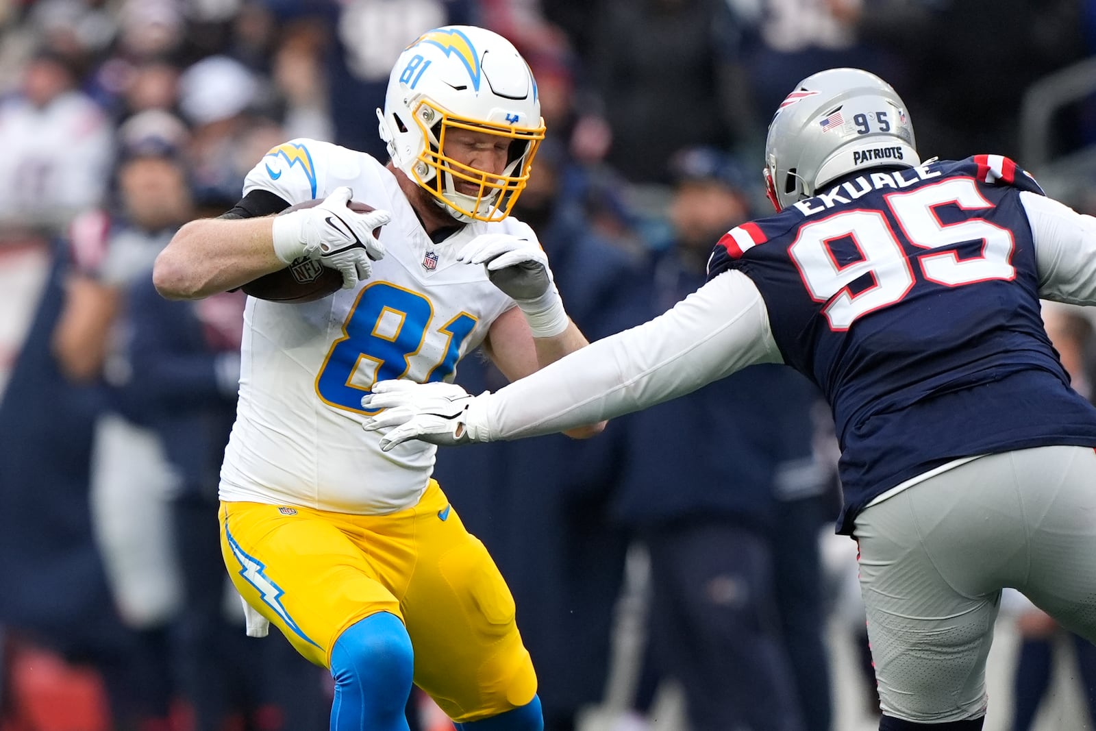 Los Angeles Chargers tight end Will Dissly (81) tries to elude New England Patriots defensive tackle Daniel Ekuale (95) during the first half of an NFL football game, Saturday, Dec. 28, 2024, in Foxborough, Mass. (AP Photo/Robert F. Bukaty)