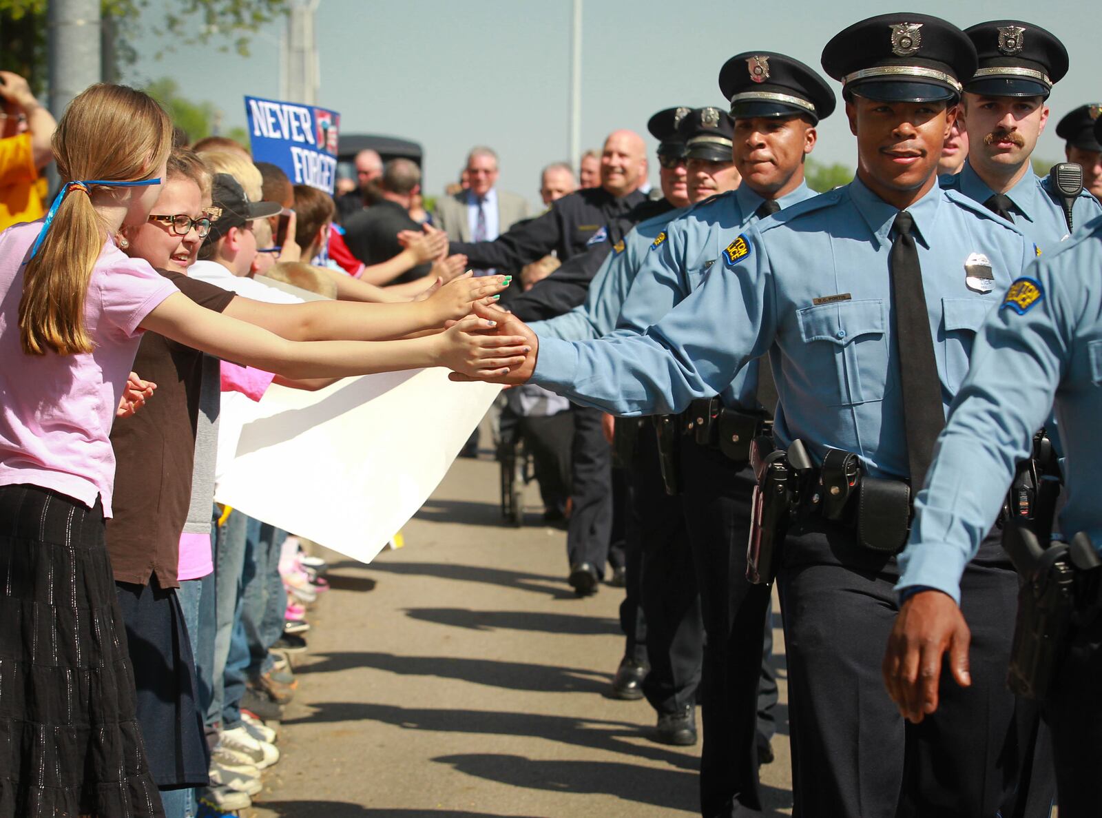 A procession of Dayton Police officers are greeted by students from Temple Christian as they walk to the RiverScape pavilion  to honor the Montgomery County law enforcement officers who have died in the line of duty. JIM WITMER/STAFF