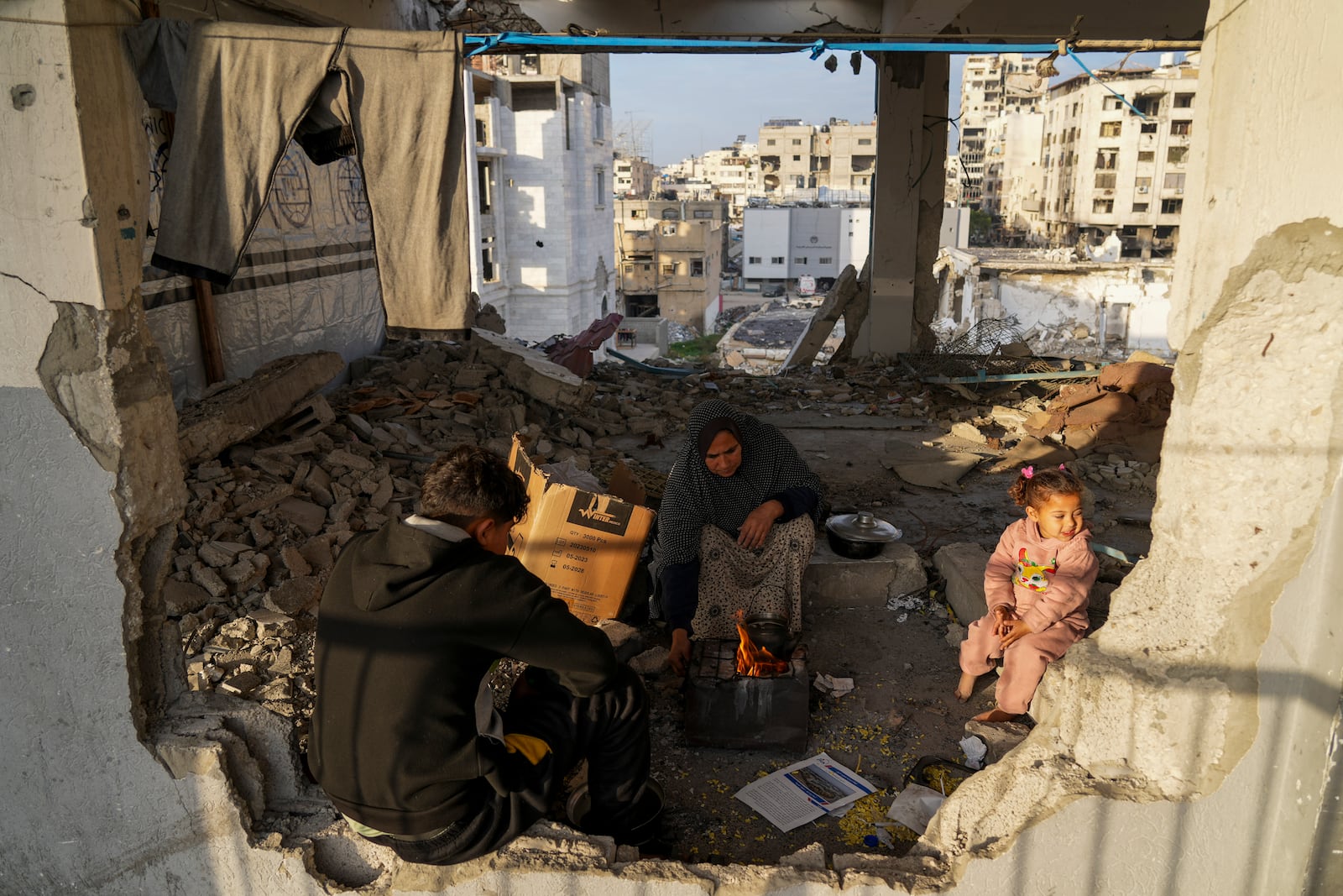 Displaced Palestinians make tea at a school run by UNRWA, the U.N. agency helping Palestinian refugees, west of Gaza City, Sunday, March 9, 2025. (AP Photo/Jehad Alshrafi)