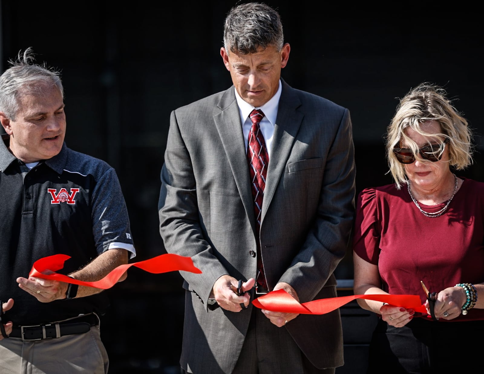 From left, Mark Combs, Jason Enix and Shannon Weldon cut the ribbon on the new Wayne High School Career Tech Center Thursday August 10, 2023, JIM NOELKER/STAFF