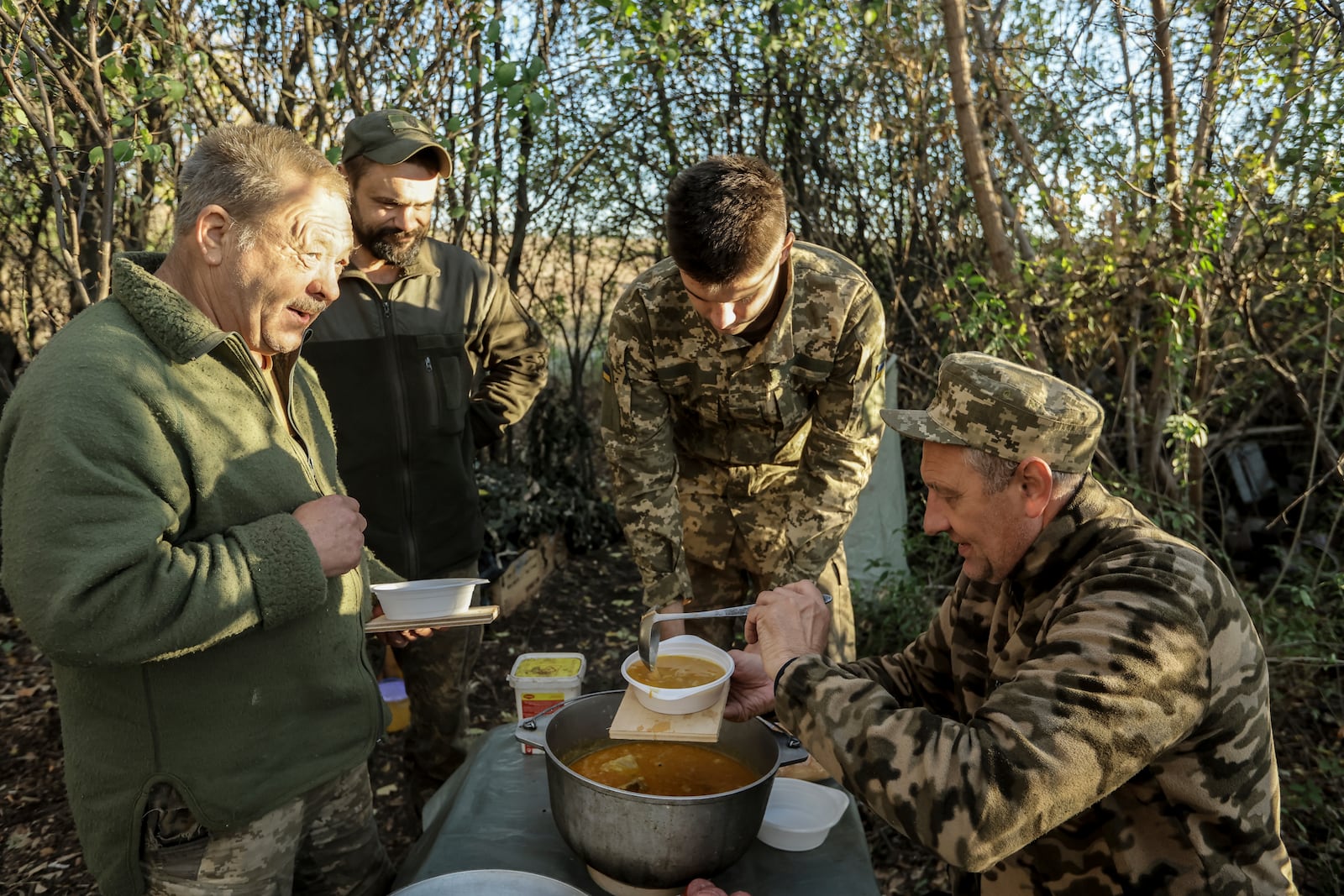 In this photo provided by Ukraine's 24th Mechanised Brigade press service, servicemen of the 24th Mechanised Brigade eat on their position in Chasiv Yar, Donetsk region, Ukraine, Wednesday, Oct. 23, 2024. (Oleg Petrasiuk/Ukrainian 24th Mechanised Brigade via AP)