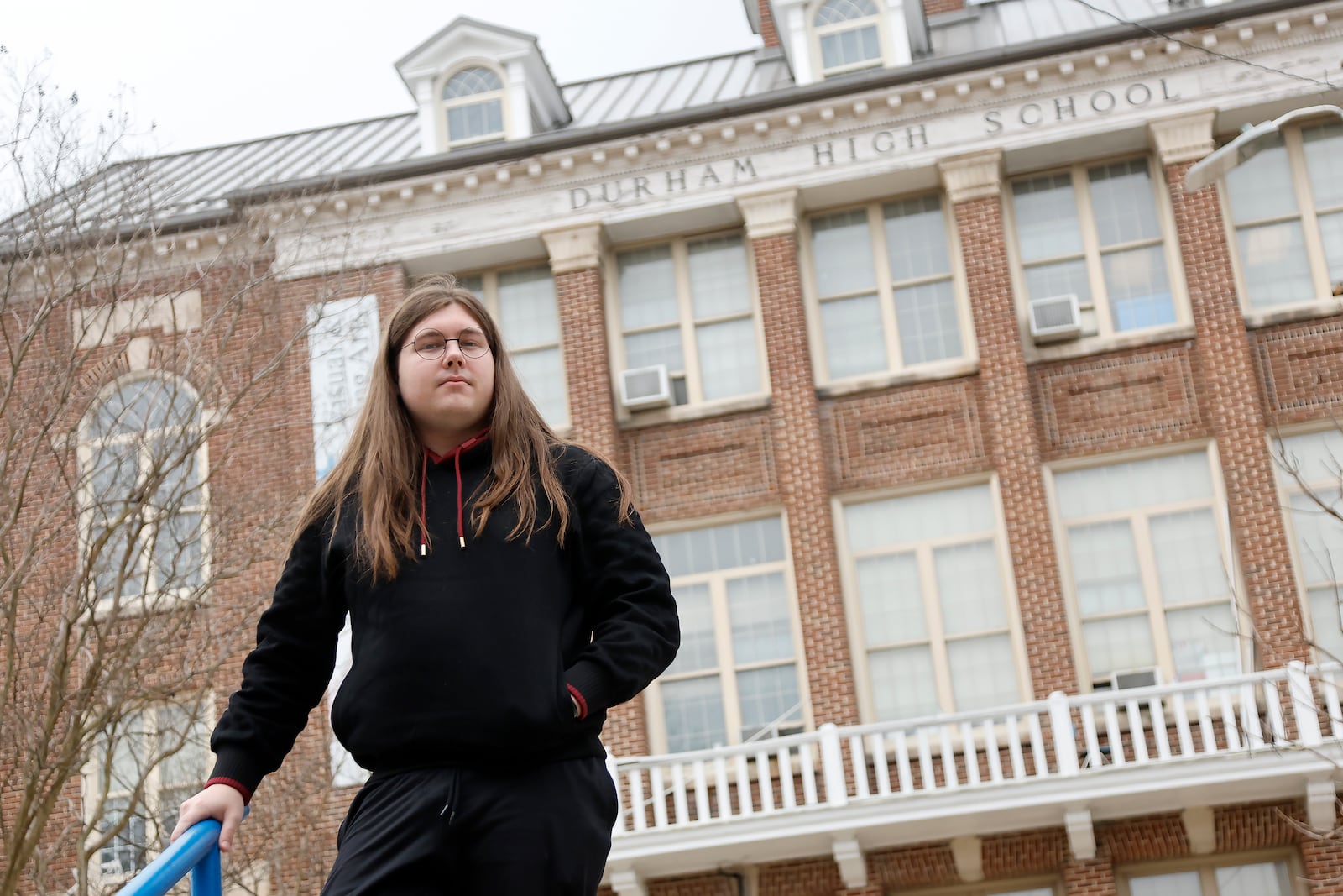 Glenn Thompson, a Durham School of the Arts graduate, poses in front of the school in Durham, N.C., Monday, March 10, 2025. (AP Photo/Karl DeBlaker)