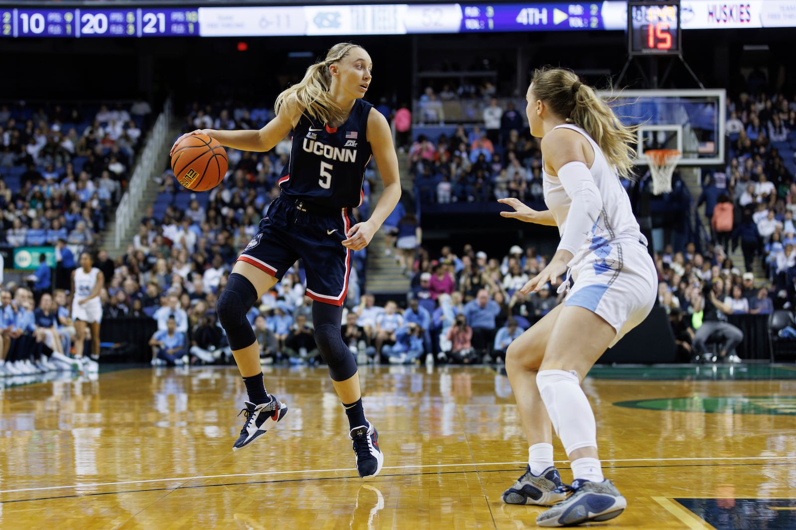 UConn's Paige Bueckers (5) handles the ball as North Carolina's Alyssa Ustby, right, defends during the second half of an NCAA college basketball game in Greensboro, N.C., Friday, Nov. 15, 2024. (AP Photo/Ben McKeown)