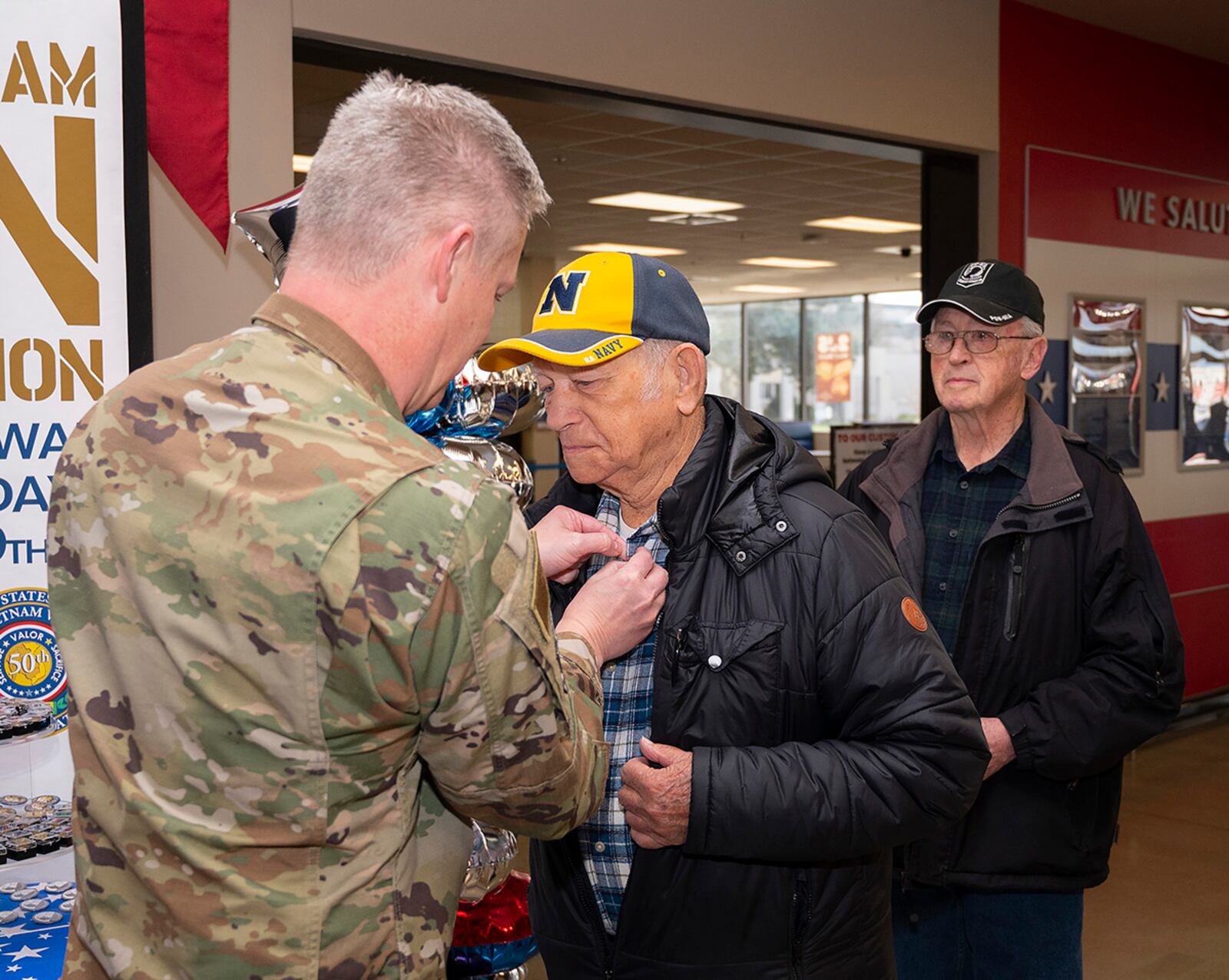 Col. Charles Barkhurst, 88th Air Base Wing vice commander, pins the lapel of Richard Wills, a Navy retiree and Vietnam War veteran, during a ceremony March 29 at Wright-Patterson Air Force Base’s Main Exchange in observance of National Vietnam War Veterans Day. U.S. AIR FORCE PHOTO/R.J. ORIEZ