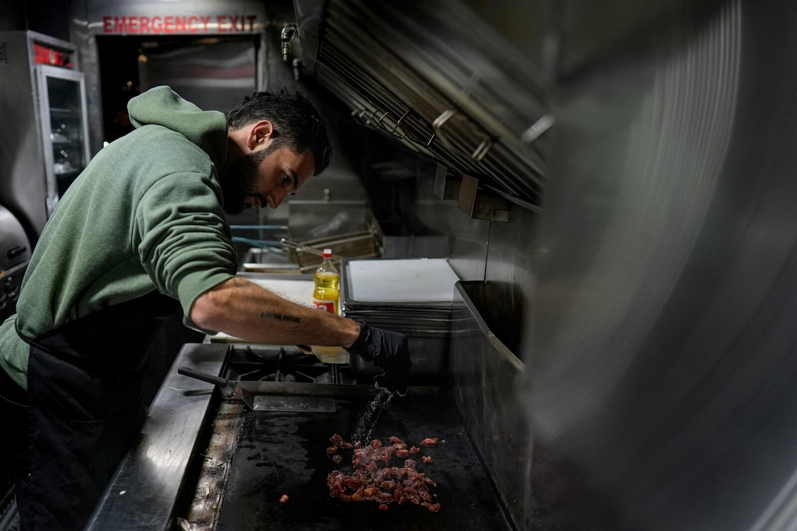 World Central Kitchen Chef Corp member Daniel Shemtob cooks meat for burritos in his food truck, The Lime Truck, for Eaton Fire first responders at the Rose Bowl Stadium, Wednesday, Jan. 15, 2025, in Pasadena, Calif. (AP Photo/Carolyn Kaster)