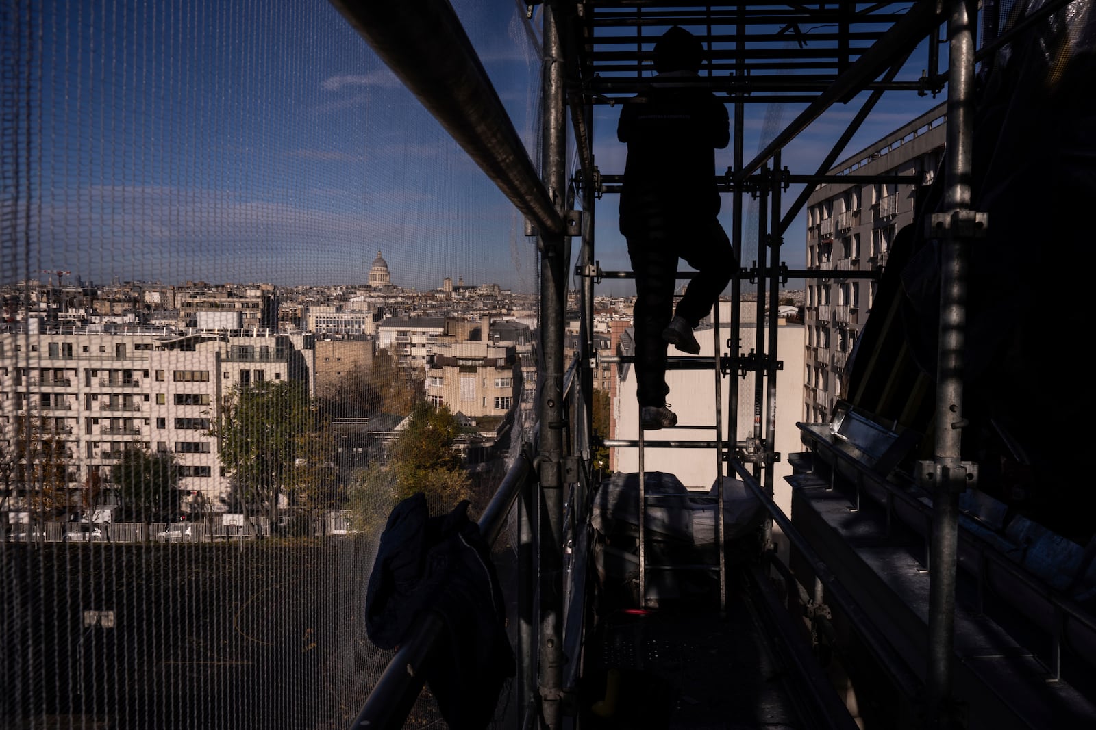 A roofer works on a building in Paris, Friday, Oct. 22, 2024. (AP Photo/Louise Delmotte)