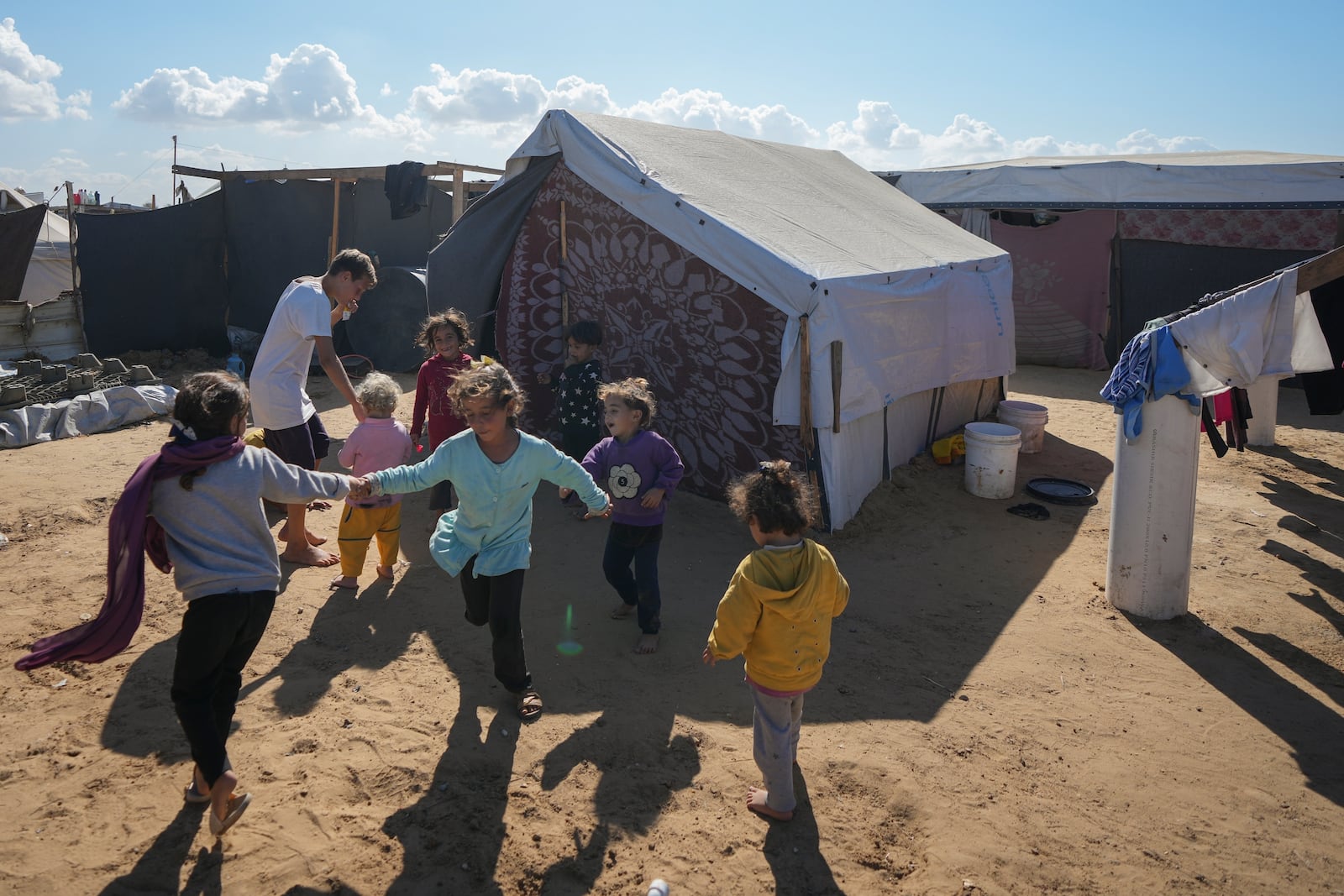 FILE - Children play next to their tent in a refugee camp in Deir al-Balah, Gaza Strip, on Tuesday, Nov. 19, 2024. (AP Photo/Abdel Kareem Hana, File)