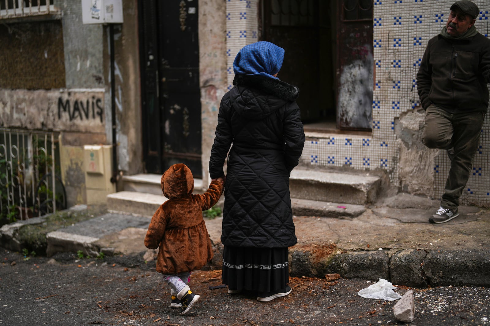 Mehmet Yeralan, 53, a volunteer, talks to a local woman with her child in the Tarlabasi neighborhood in Istanbul, Turkey, Wednesday, Dec. 4, 2024. (AP Photo/Francisco Seco)