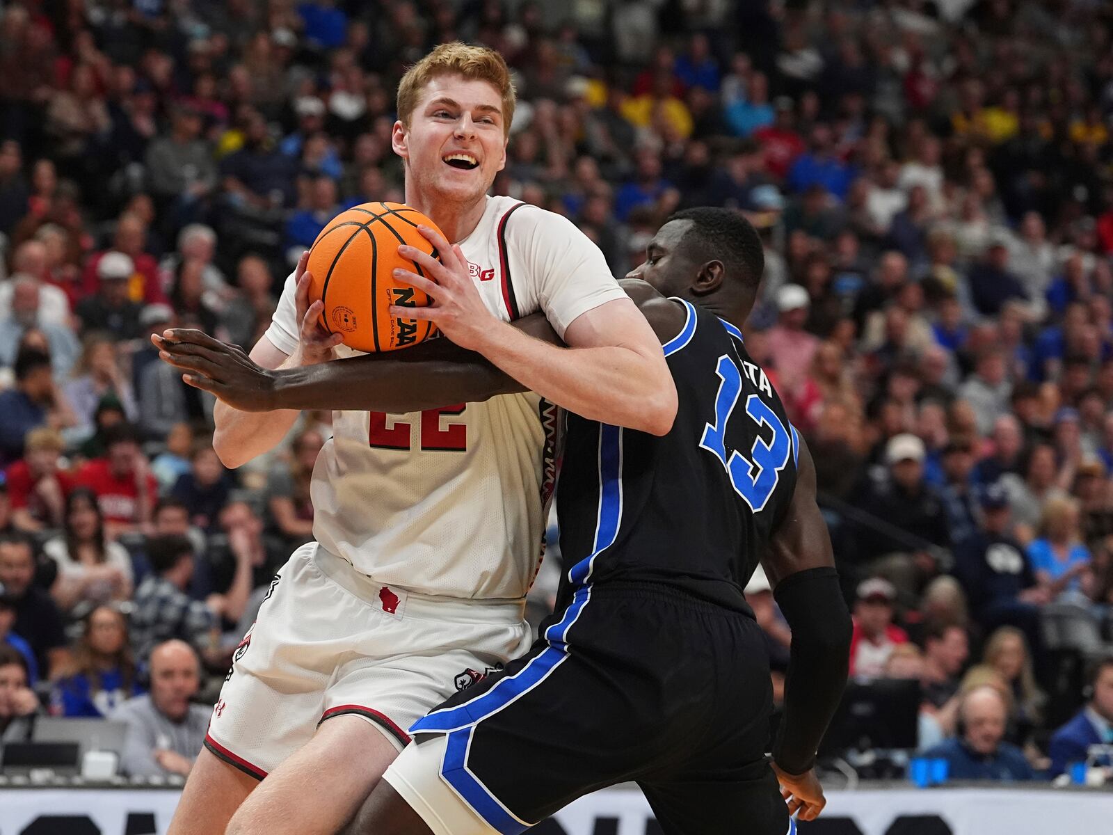 Wisconsin forward Steven Crowl, left, drives past Brigham Young center Keba Keita during the first half in the second round of the NCAA college basketball tournament Saturday, March 22, 2025, in Denver. (AP Photo/David Zalubowski)