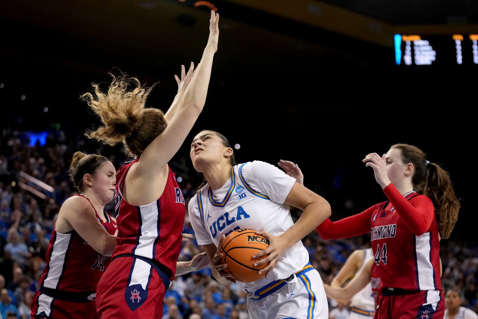 UCLA center Lauren Betts, center, goes to the basket against Richmond guard Ally Sweeney (14), and forwards Addie Budnik (20) and Maggie Doogan (44) during the first half in the second round of the NCAA college basketball tournament Sunday, March 23, 2025, in Los Angeles. (AP Photo/Eric Thayer)