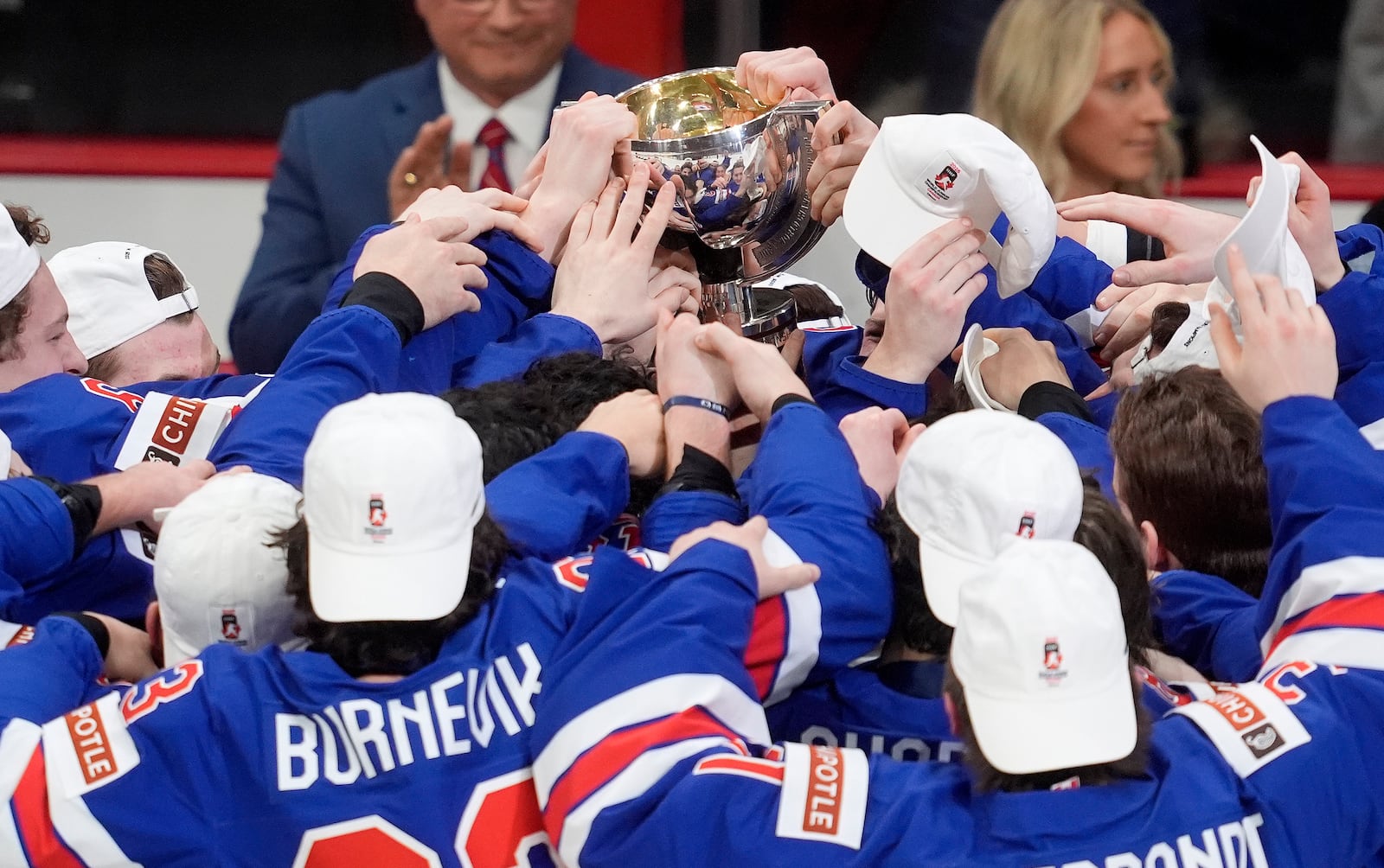 United States players reach for the trophy following their IIHF World Junior Hockey Championship gold medal game win over Finland, in Ottawa, Ontario, Sunday, Jan. 5, 2025. (Adrian Wyld/The Canadian Press via AP)