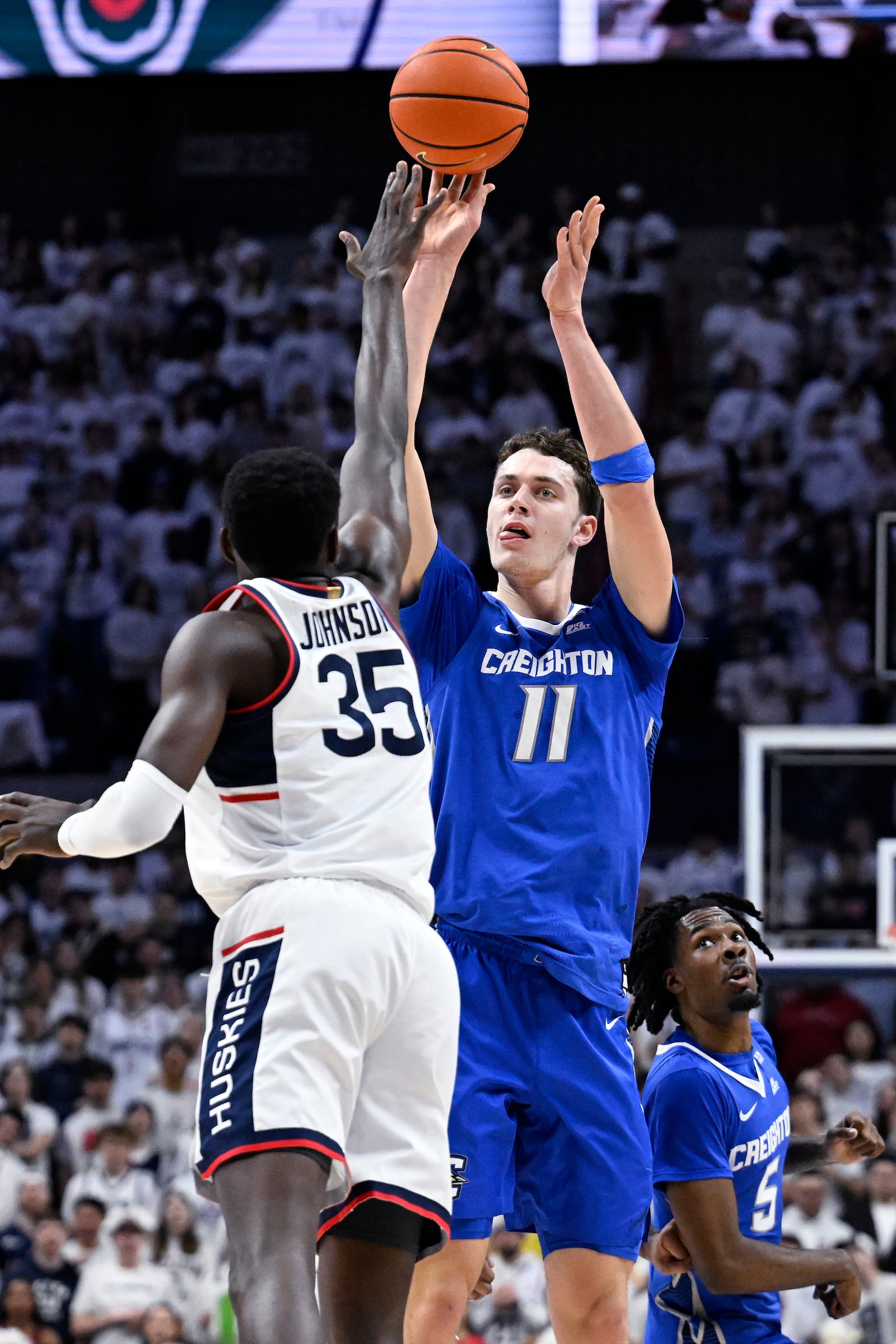 Creighton center Ryan Kalkbrenner (11) shoots over UConn center Samson Johnson (35) in the first half of an NCAA college basketball game, Saturday, Jan. 18, 2025, in Storrs, Conn. (AP Photo/Jessica Hill)