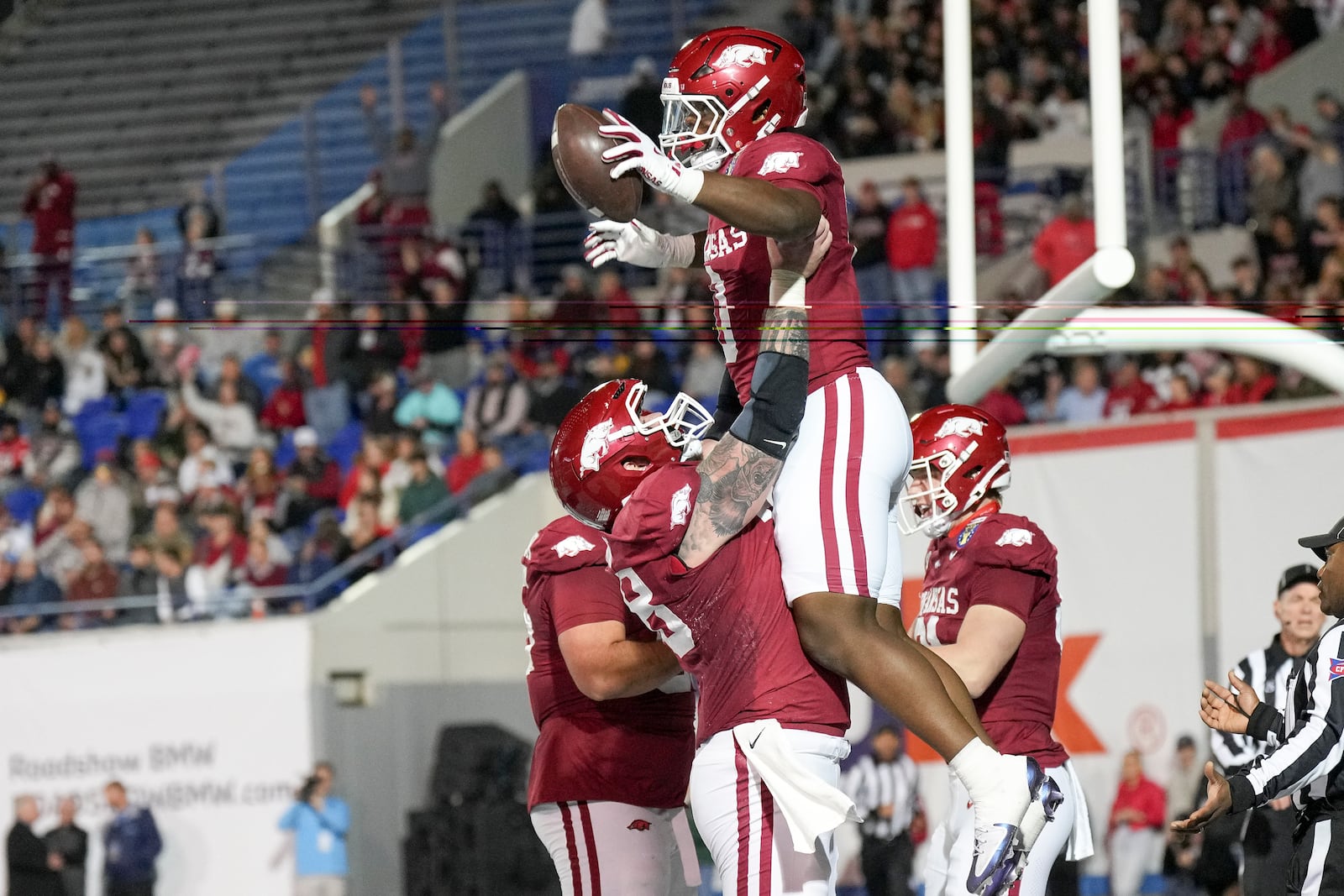 Arkansas running back Braylen Russell, top, celebrates his touchdown with a teammate during the first half of the Liberty Bowl NCAA college football game against Texas Tech, Friday, Dec. 27, 2024, in Memphis, Tenn. (AP Photo/George Walker IV)