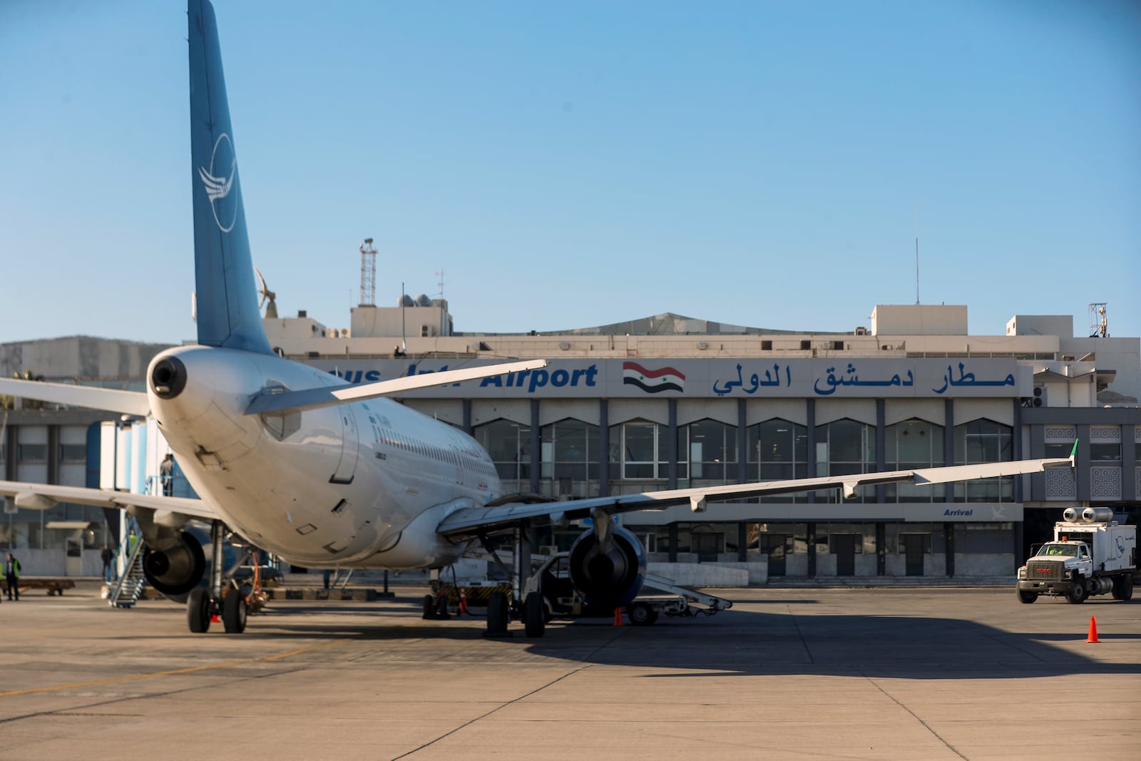 A Syrian Air airplane is seen parked at the terminal as the airport reopens for internal flights in Damascus, Syria, Wednesday, Dec. 18, 2024. (AP Photo/Omar Sanadiki)