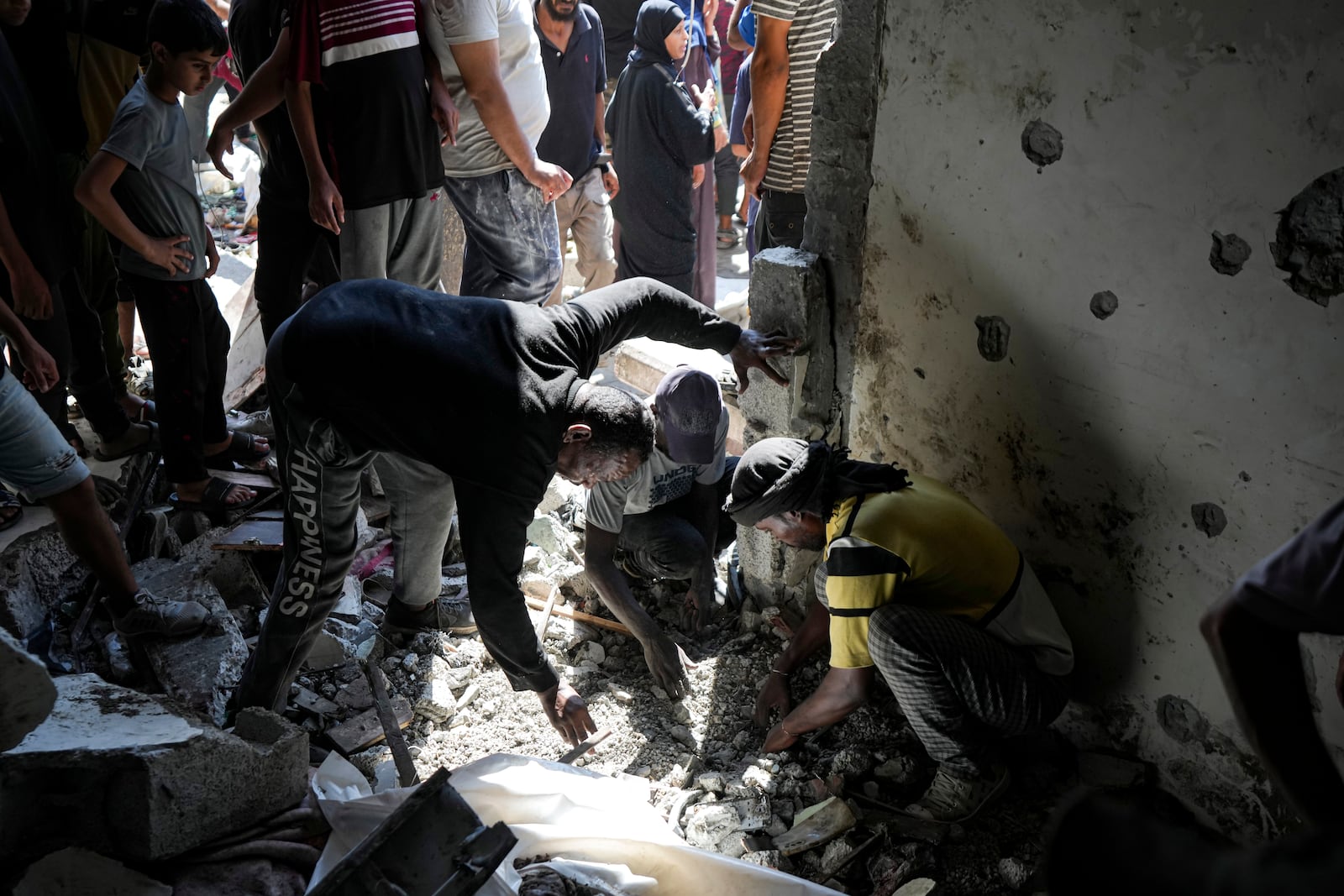 Palestinians search for the remains of their relatives killed in an Israeli bombardment of a school in Deir al-Balah, central Gaza Strip, Thursday, Oct. 10, 2024. (AP Photo/Abdel Kareem Hana)