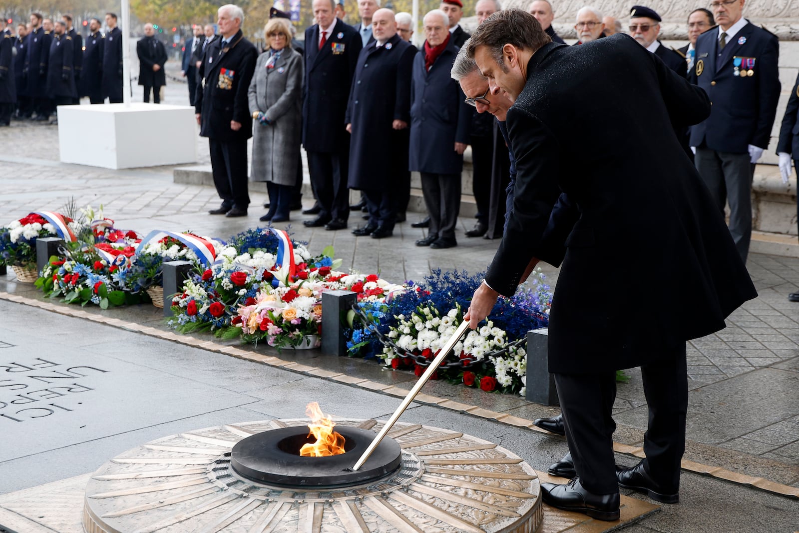 French President Emmanuel Macron, right, and British Prime Minister Keir Starmer revive the flame on the Unknown Soldiers's Tomb under the Arc de Triomphe during commemorations marking the 106th anniversary of the November 11, 1918, Armistice, ending World War I, at the Arc de Triomphe in Paris, Monday, Nov. 11, 2024. ( Ludovic Marin, Pool via AP)