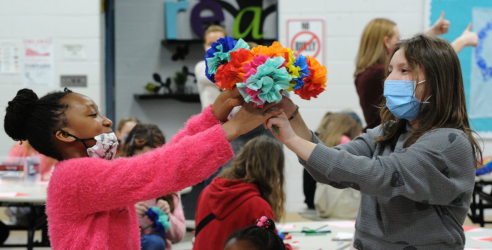 Students Averi Hurt, left and Cora Smith work on making paper flowers for a local nursing home at a Valentine's Day party at Stingley Elementary in Centerville on Friday, Feb. 11, 2022. The PTO is doing a fundraiser where students do acts of kindness in return for donations to the school. MARSHALL GORBY\STAFF