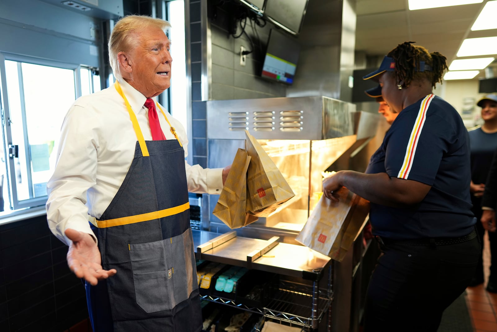 Republican presidential nominee former President Donald Trump holds an order near the drive-thru window during a visit to McDonald's in Feasterville-Trevose, Pa., Sunday, Oct. 20, 2024. (Doug Mills/The New York Times via AP, Pool)