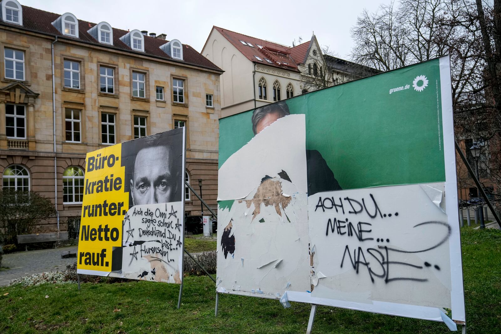 Defaces election posters of Green Party top candidate and federal minister for economy Robert Habeck, right, and FDP top candidate and former finance minister Christian Lindner, are seen is a street, in Magdeburg, Germany, Friday, Feb. 7, 2025. (AP Photo/Ebrahim Noroozi)