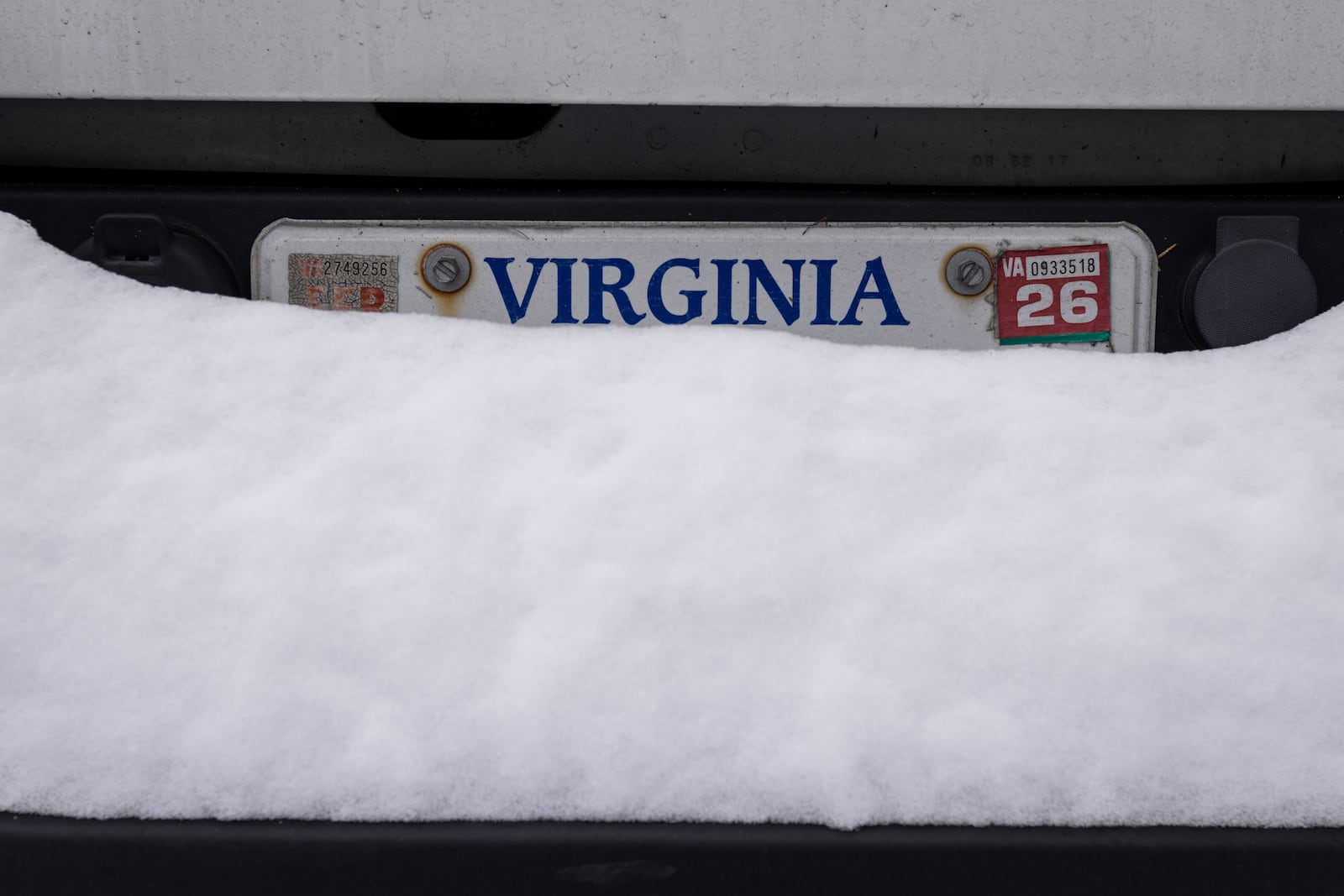 Snow build up covers the license plate of a parked car after around 10 inches of snow fell over Norfolk, Va on Thursday, Feb. 20, 2025. (Billy Schuerman /The Virginian-Pilot via AP)