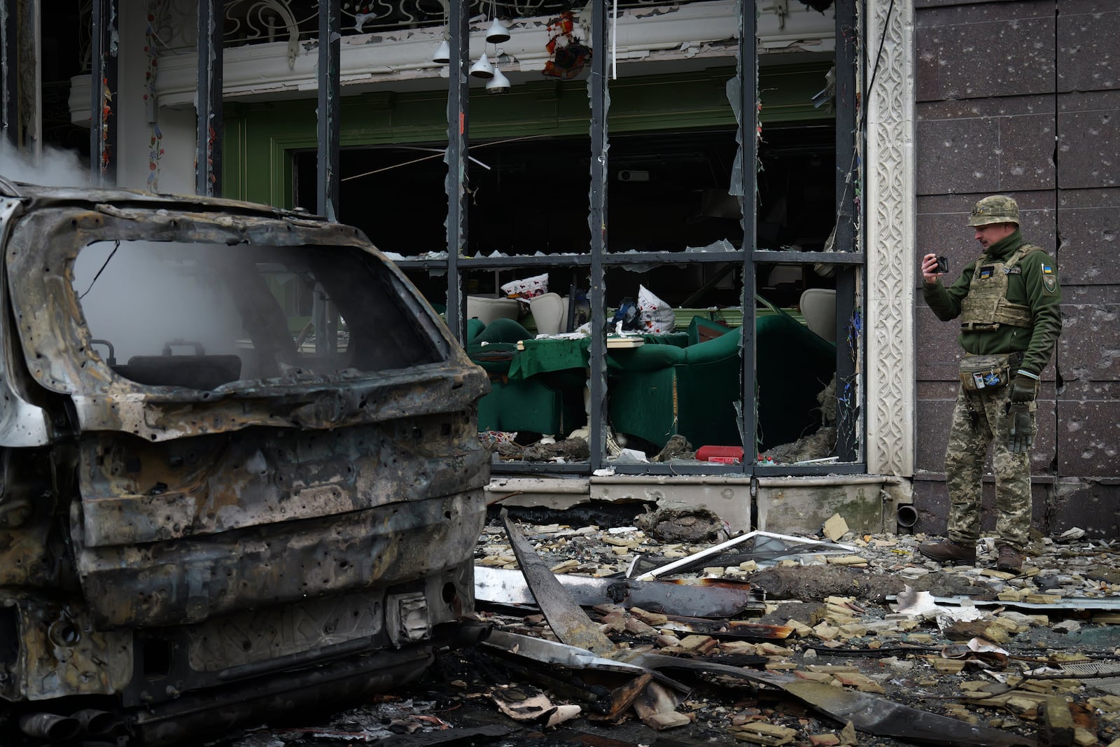 A Ukrainian serviceman collects evidence following recent Russian attacks in Kyiv, Ukraine, Friday, Dec. 20, 2024. (AP Photo/Daniil Bashakov)