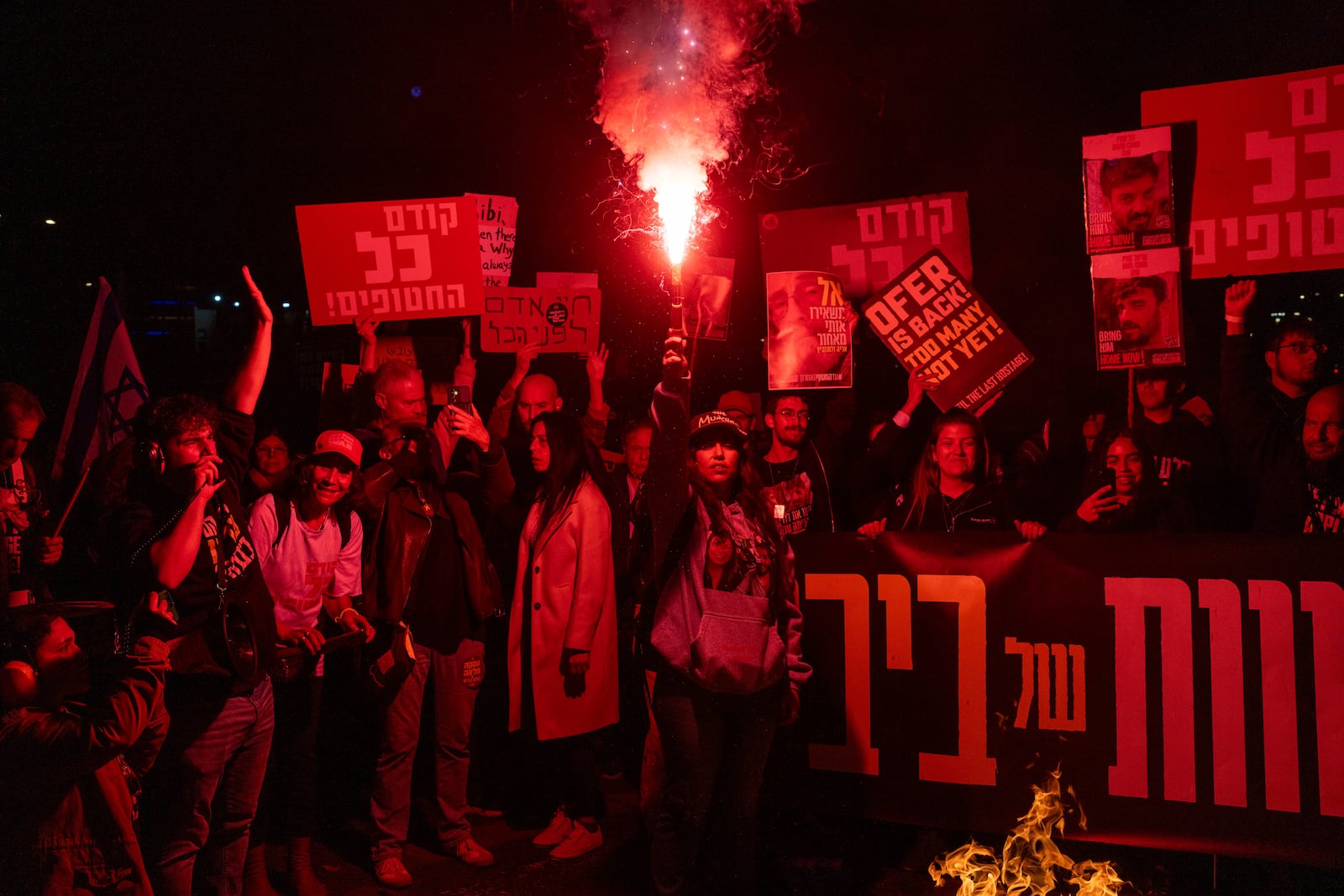 Relatives of hostages and demonstrators light flares during a protest demanding a ceasefire deal and the immediate release of hostages held by Hamas in the Gaza Strip on Sunday, March 9, 2025, in Tel Aviv, Israel. (AP Photo/Ohad Zwigenberg)