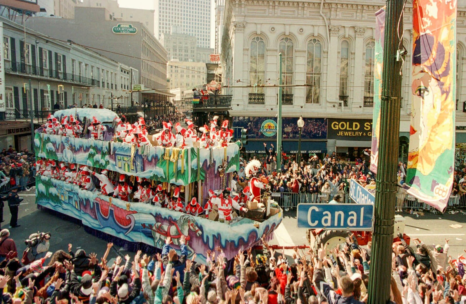 FILE - Mardi Gras revelers greet a float from the Zulu parade at the corner of St. Charles and Canal Streets in New Orleans, La., on Mardi Gras day Tuesday, Feb. 11, 1997. (AP Photo/Andrew J. Cohoon, File)