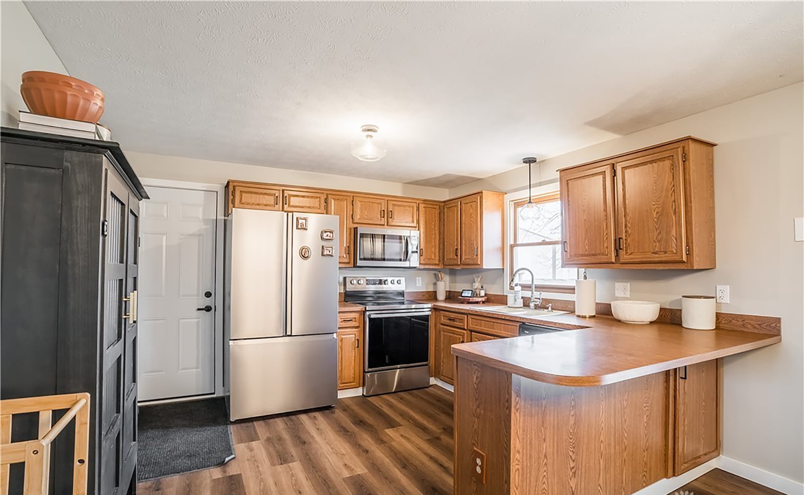 The kitchen has luxury vinyl tile flooring, a breakfast bar and eat in dining area as well as newer stainless appliances.