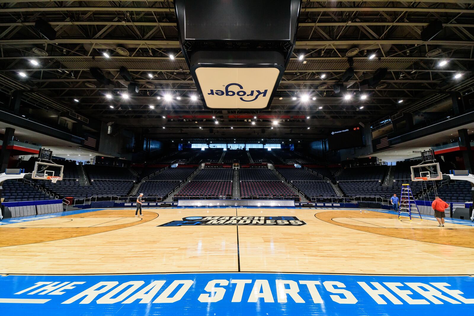 On St. Patrick's Day 2024, workers put the finishing touches on the basketball court installation for the First Four of the NCAA Division I Men’s Basketball Championship at UD Arena which will take place on March 19 & 20, 2024. TOM GILLIAM / CONTRIBUTING PHOTOGRAPHER