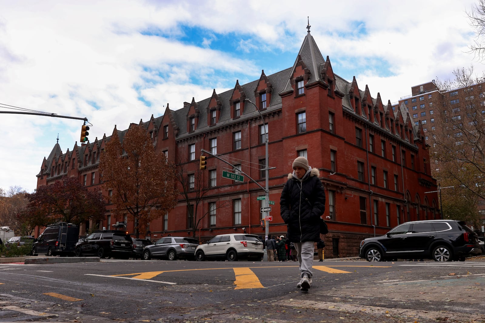 A woman crosses Amsterdam Avenue outside the HI New York City hostel, Thursday, Dec. 5, 2024, in New York, where police say the suspect in the killing of UnitedHealthcare CEO Brian Thompson may have stayed.(AP Photo/Yuki Iwamura)