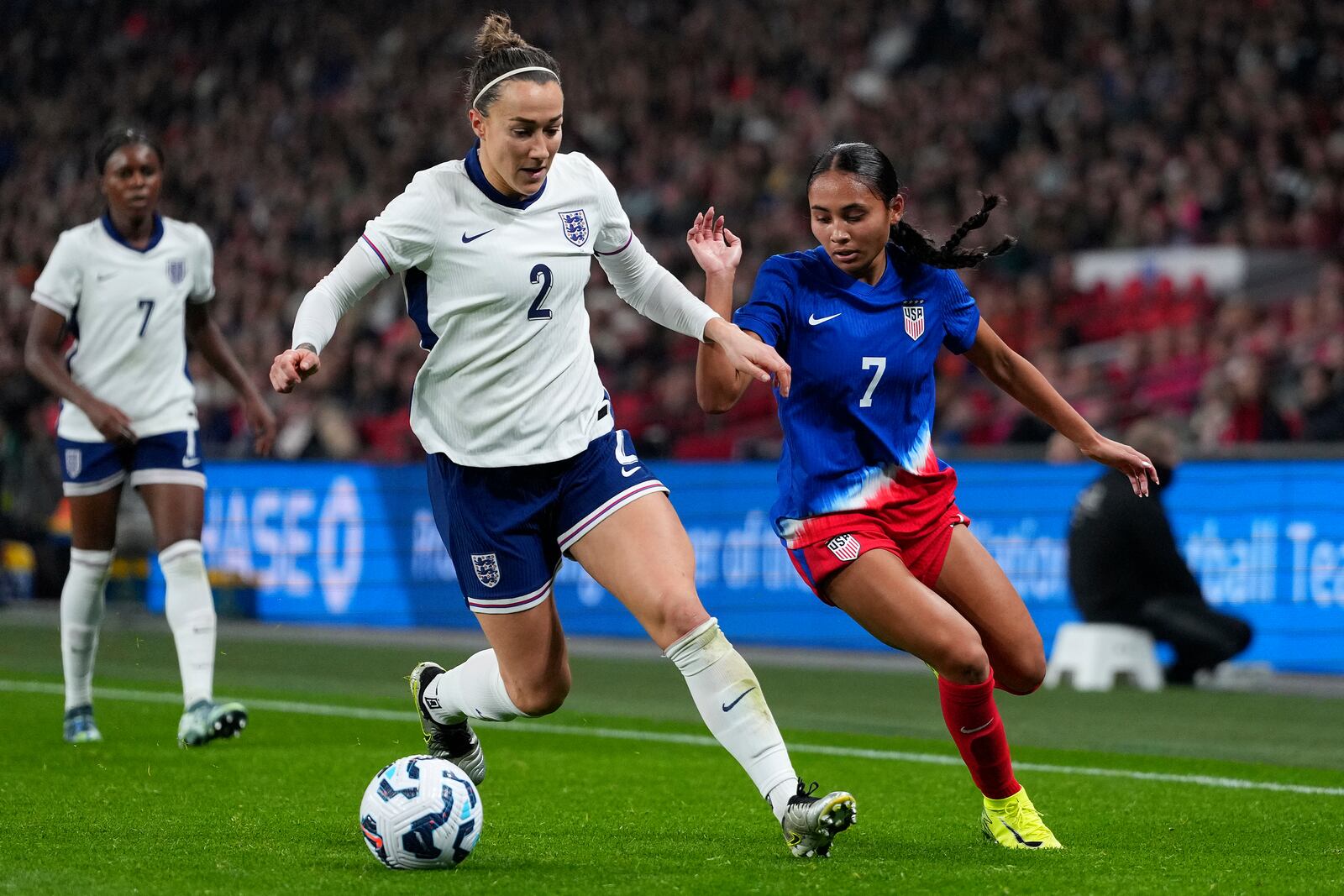 England's Lucy Bronze and United States' Alyssa Thompson, right, challenge for the ball during the International friendly women soccer match between England and United States at Wembley stadium in London, Saturday, Nov. 30, 2024. (AP Photo/Kirsty Wigglesworth)