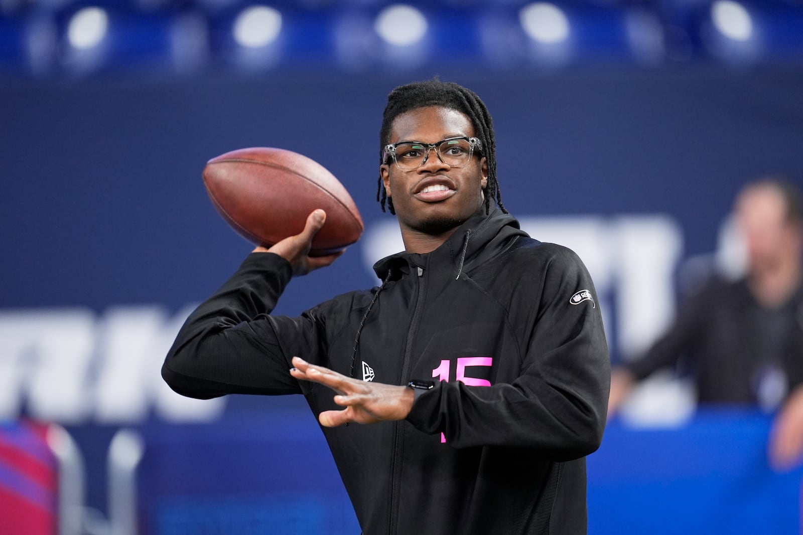 Colorado defensive back Travis Hunter tosses a football as he watches drills at the NFL football scouting combine in Indianapolis, Friday, Feb. 28, 2025. (AP Photo/George Walker IV)