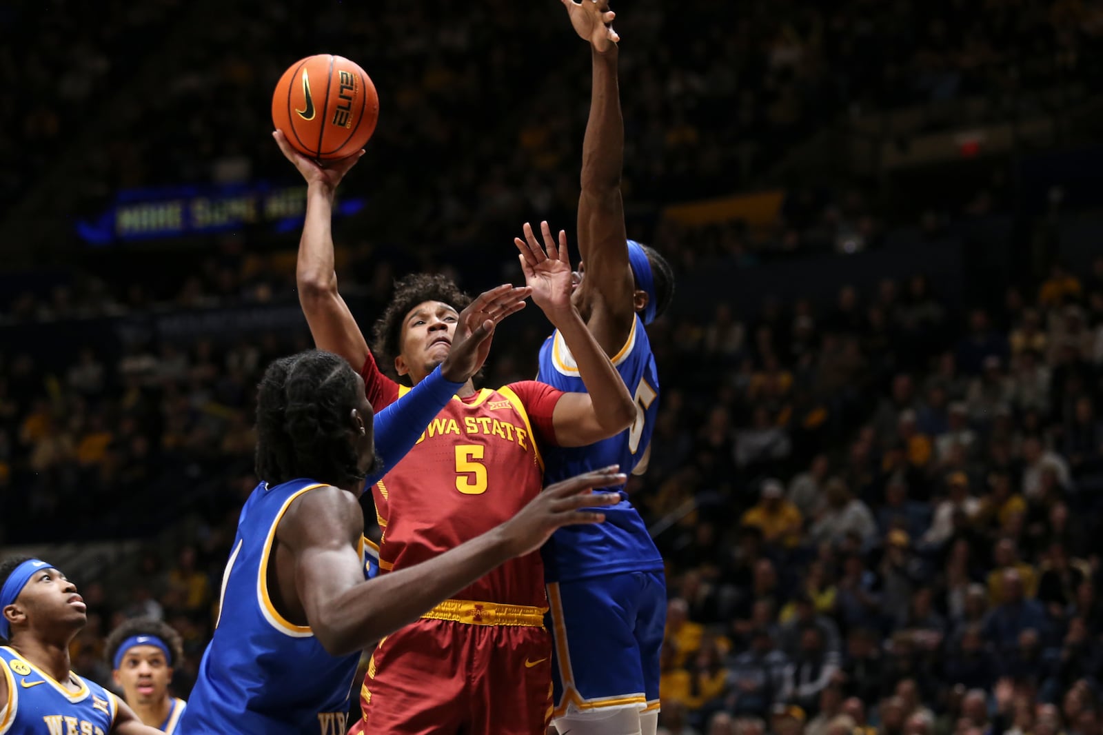 Iowa State guard Curtis Jones (5) shoots while being guarded by West Virginia guard Toby Okani (5) during the first half of an NCAA college basketball game, Saturday, Jan. 18, 2025, in Morgantown, W.Va. (AP Photo/William Wotring)