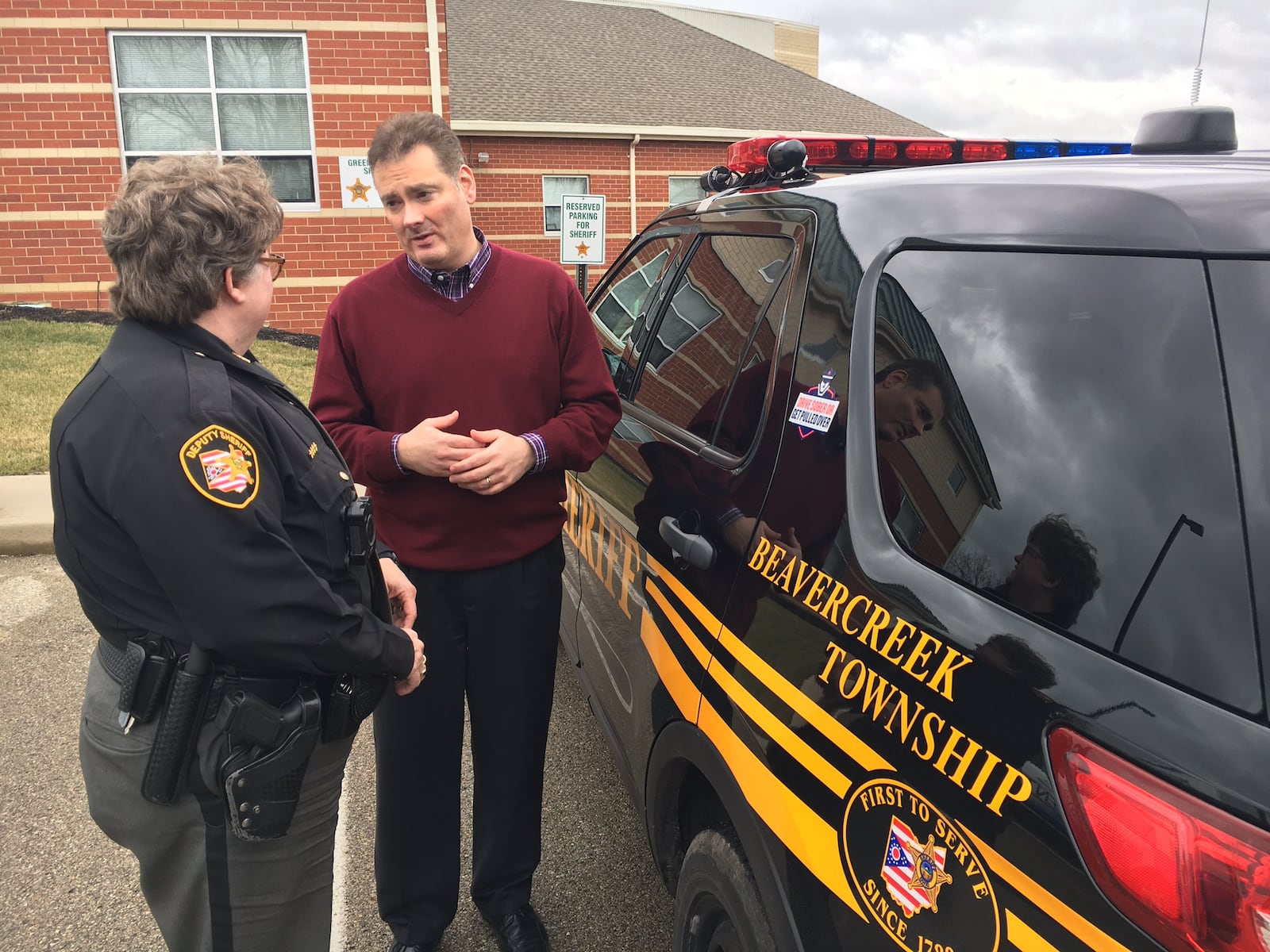 In this file photo, then Beavercreek Twp. Administrator Alex Zaharieff talks to a Greene County Sheriff’s deputy at the Beavercreek Twp. sheriff's substation. STAFF FILE PHOTO