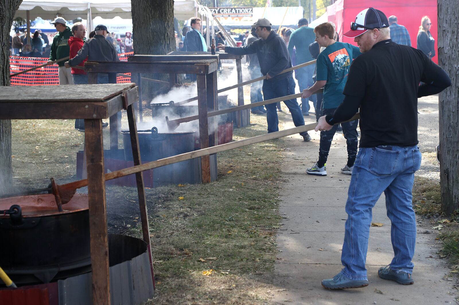 Volunteers take turns stirring the kettles of apple butter Saturday, Oct. 8, 2022 at the Enon Apple Butter Festival. BILL LACKEY/STAFF