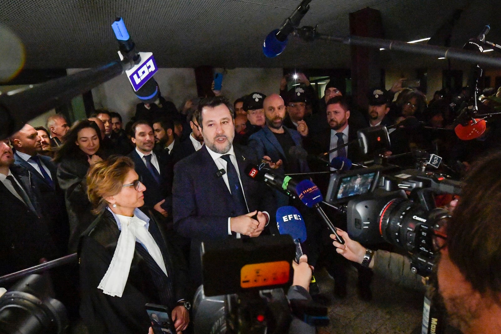 Italy's vice Premier Matteo Salvini, flanked by his lawyer Giulia Bongiorno, left, speaks to journalists as he leaves a Palermo's law court in Sicily, Italy, Friday, Dec. 20, 2024, after he was acquitted in a first instance trial where he was accused of blocking for 19 days the disembarkation of 147 people, including minors, rescued at sea by the NGO Open Arms in August 2019.(AP Photo/Salvatore Cavalli)