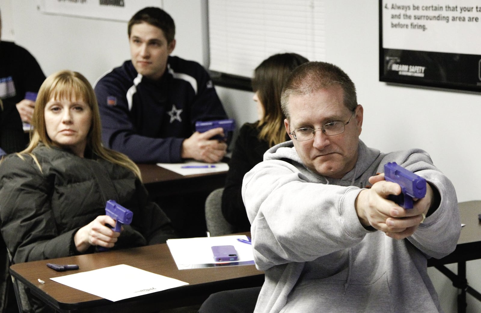 Students hold dummy guns in a basic “First Shots” introductory firearms course taught by Jim Kokaly, a NRA certified instructor, on Jan. 24, 2013, at Sim Trainer in Moraine. CHRIS STEWART / STAFF