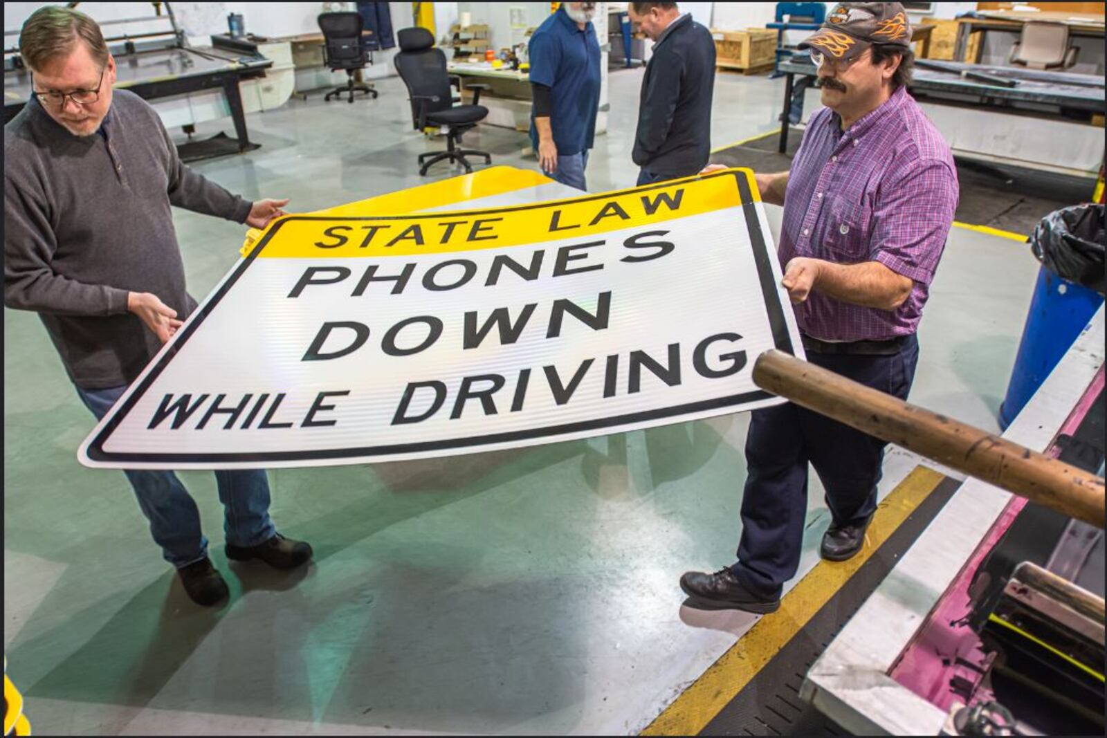 Ohio Department of Transportation employees make new signs to be posted throughout the state at 45 locations on interstate and U.S. highways warning motorists to put down cell phones while driving. CONTRIBUTED/OHIO DEPARTMENT OF TRANSPORTATION