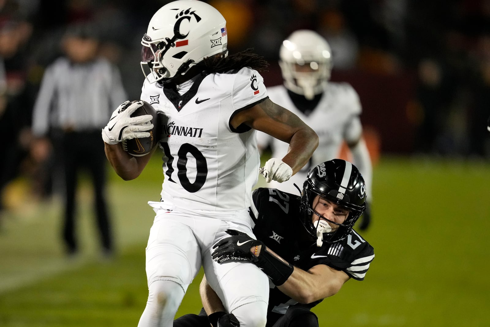 Iowa State's Tripp Walsh (27) tackles Cincinnati wide receiver Jamoi Mayes (10) during the first half of an NCAA college football game, Saturday, Nov. 16, 2024, in Ames, Iowa. (AP Photo/Charlie Neibergall)