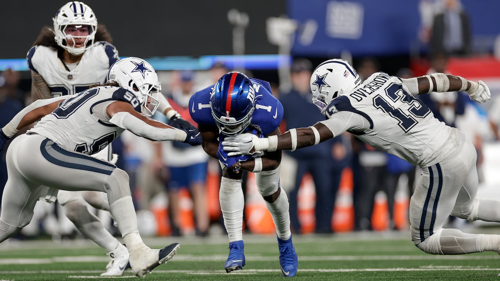 New York Giants wide receiver Malik Nabers (1) carries the ball against Dallas Cowboys linebacker DeMarvion Overshown (13) and linebacker Eric Kendricks (50) during the fourth quarter of an NFL football game, Thursday, Sept. 26, 2024, in East Rutherford, N.J. (AP Photo/Adam Hunger)