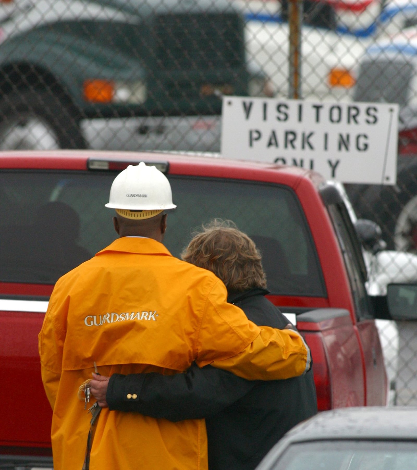 Security guards for Watkins Motor Lines in West Chester hug outside the trucking docks after two people were killed and three others injured in a shooting rampage in November 2003.