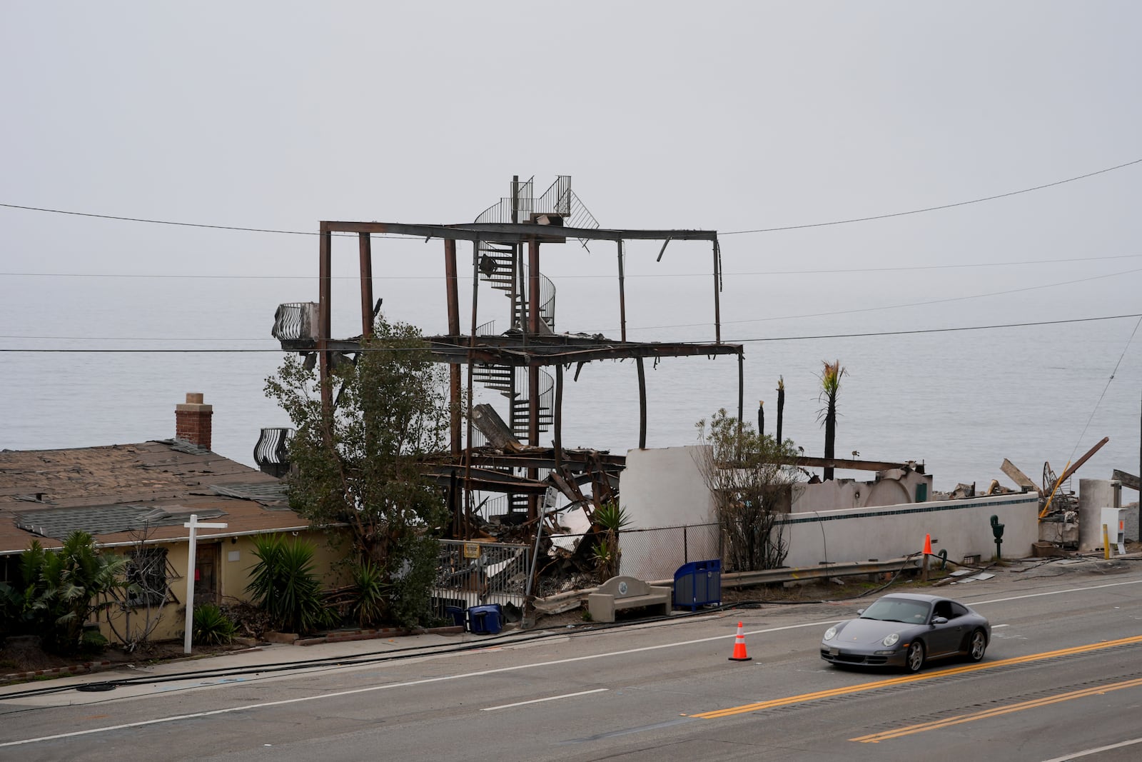 Motorists make their way along Pacific Coast Highway past beachfront homes destroyed by the Palisades Fire Monday, Feb. 3, 2025, in Malibu, Calif. (AP Photo/Damian Dovarganes)