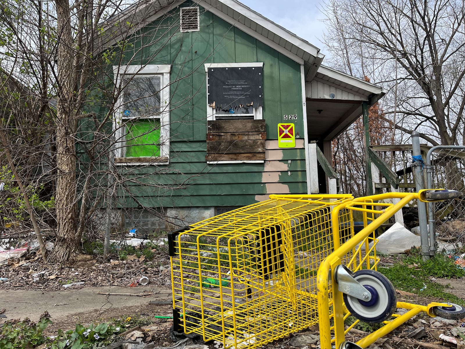 Trash and debris piled up in front of a vacant and abandoned home on Parrot Street in East Dayton. CORNELIUS FROLIK / STAFF