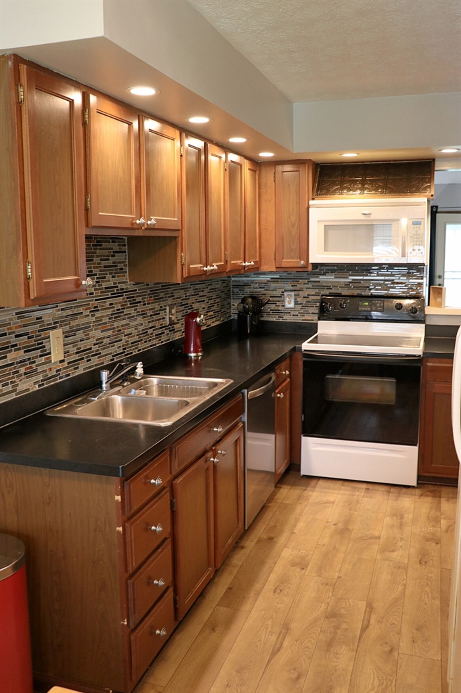 The eat-in kitchen has dark Corian counters that complement the wood cabinetry. 