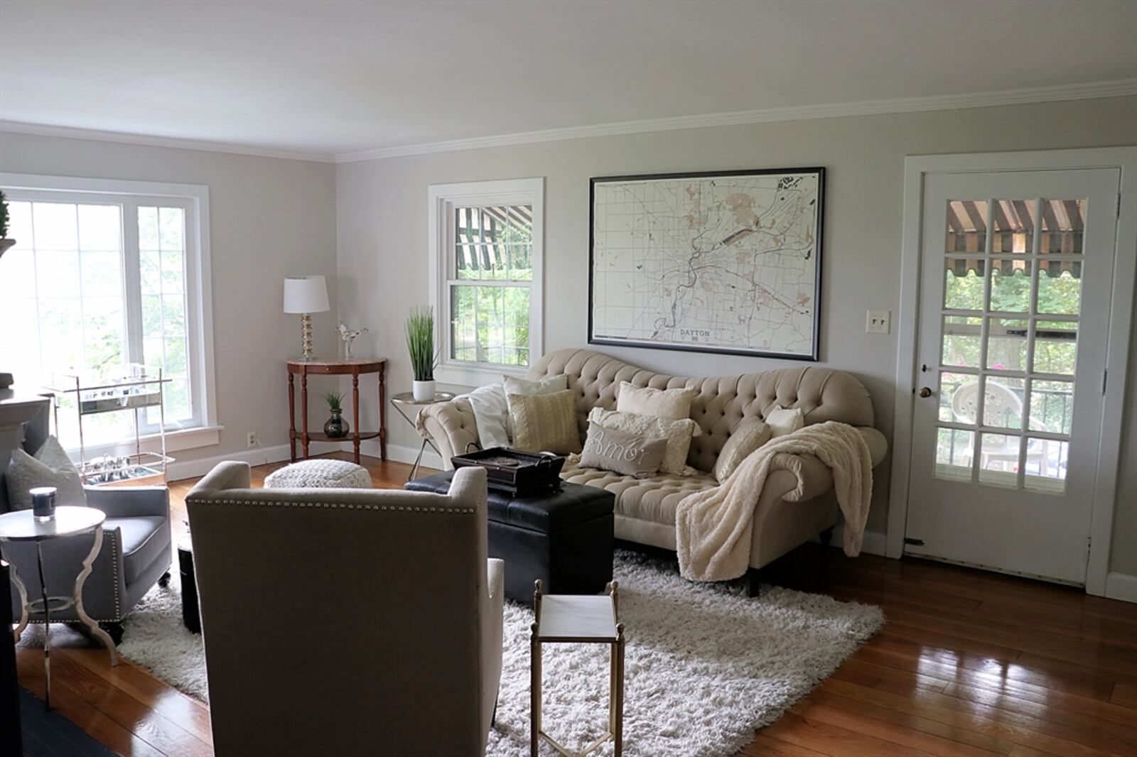 The formal living room has picture-window views of the golf course. A glass door opens to an awning-covered balcony patio that looks over the side courtyard and golf course. 