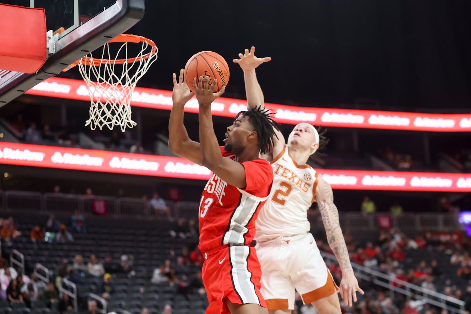 Ohio State forward Sean Stewart (13) shoots past Texas guard Chendall Weaver (2) during the first half of an NCAA basketball game Monday, Nov. 4, 2024, in Las Vegas. (AP Photo/Ian Maule)